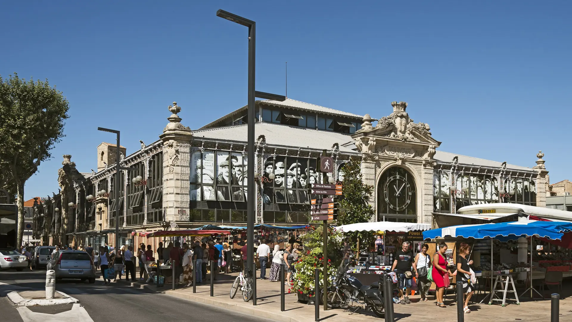 The glass-and-iron façade of Les Halles market in sunny central Narbonne