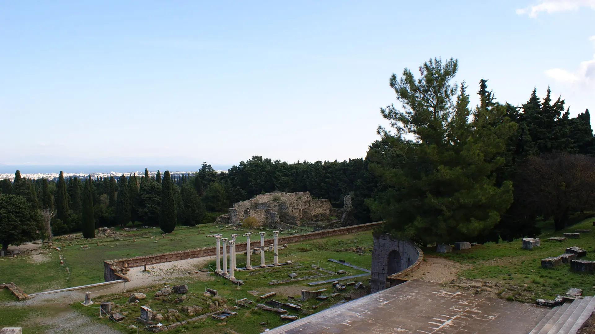 Ancient terraces and columns of the Asklepieion of Kos beneath a pale blue sky
