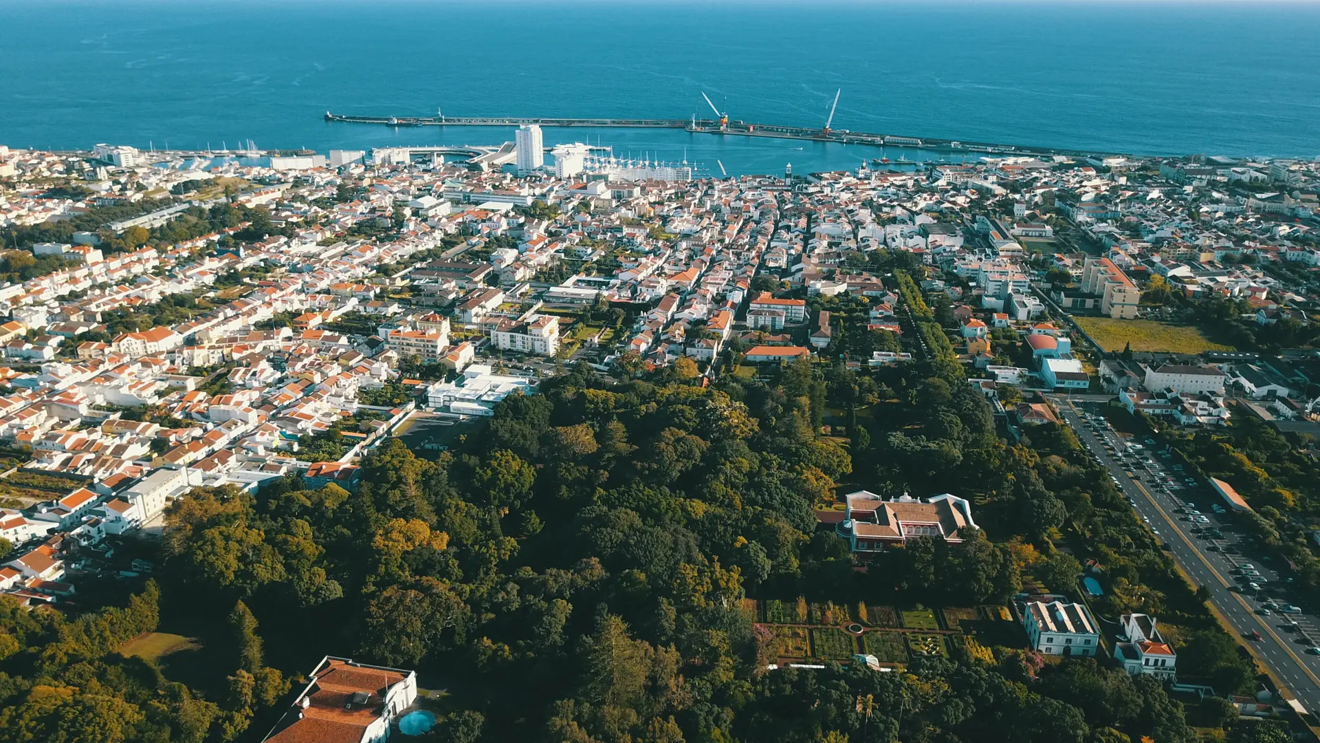 an aerial view of Ponta Delgada's marina and harbour with the city and vivid blue Atlantic