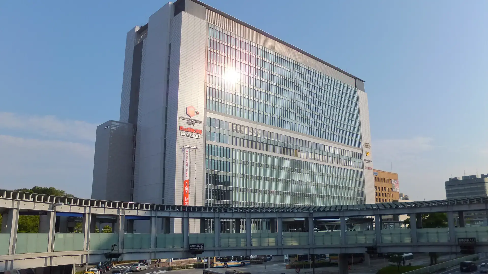 sunlit Shin-Yokohama Station district with modern towers and broad pedestrian spaces