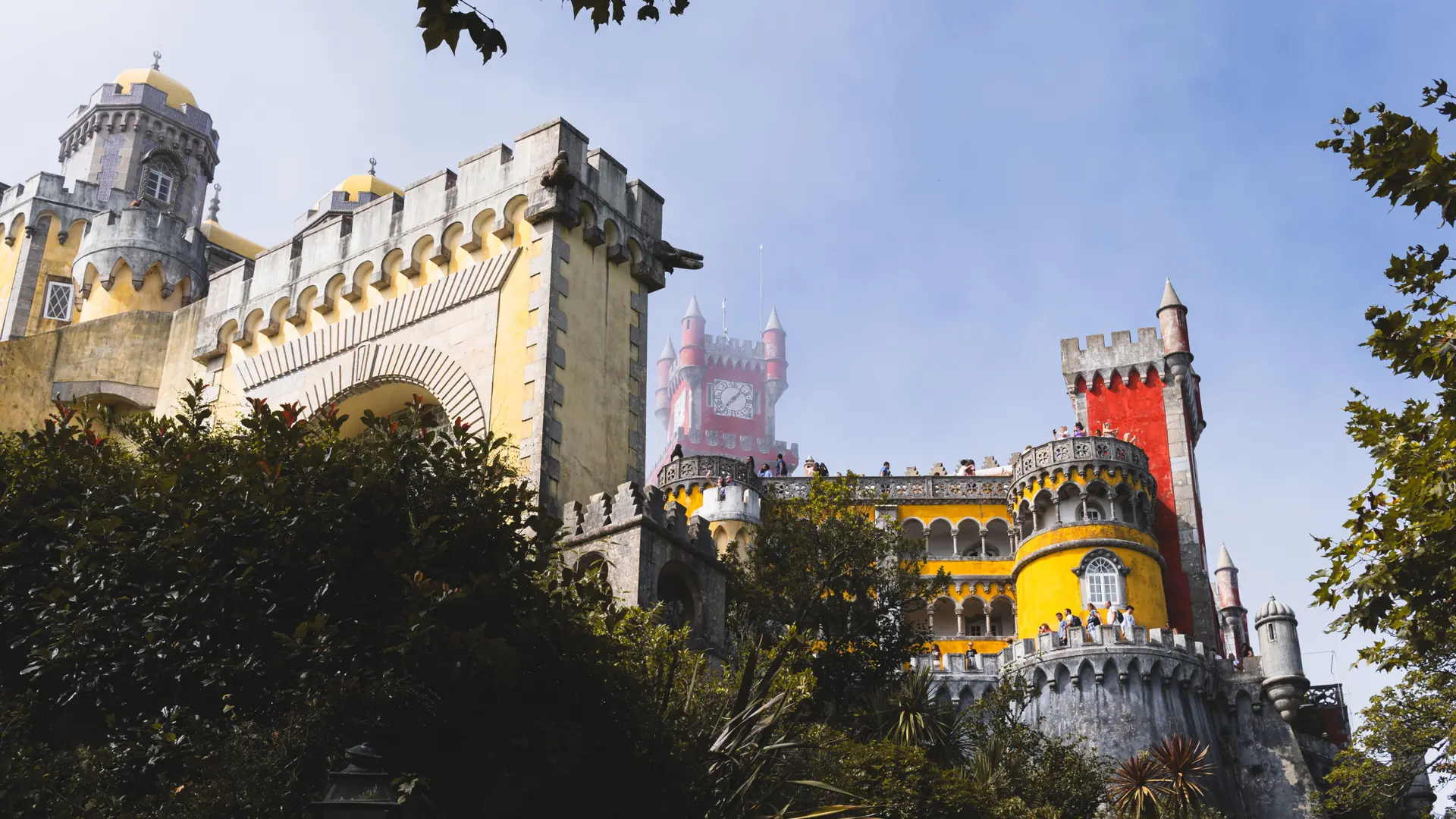 Pena Palace glimpsed through trees on Sintra’s wooded ridge