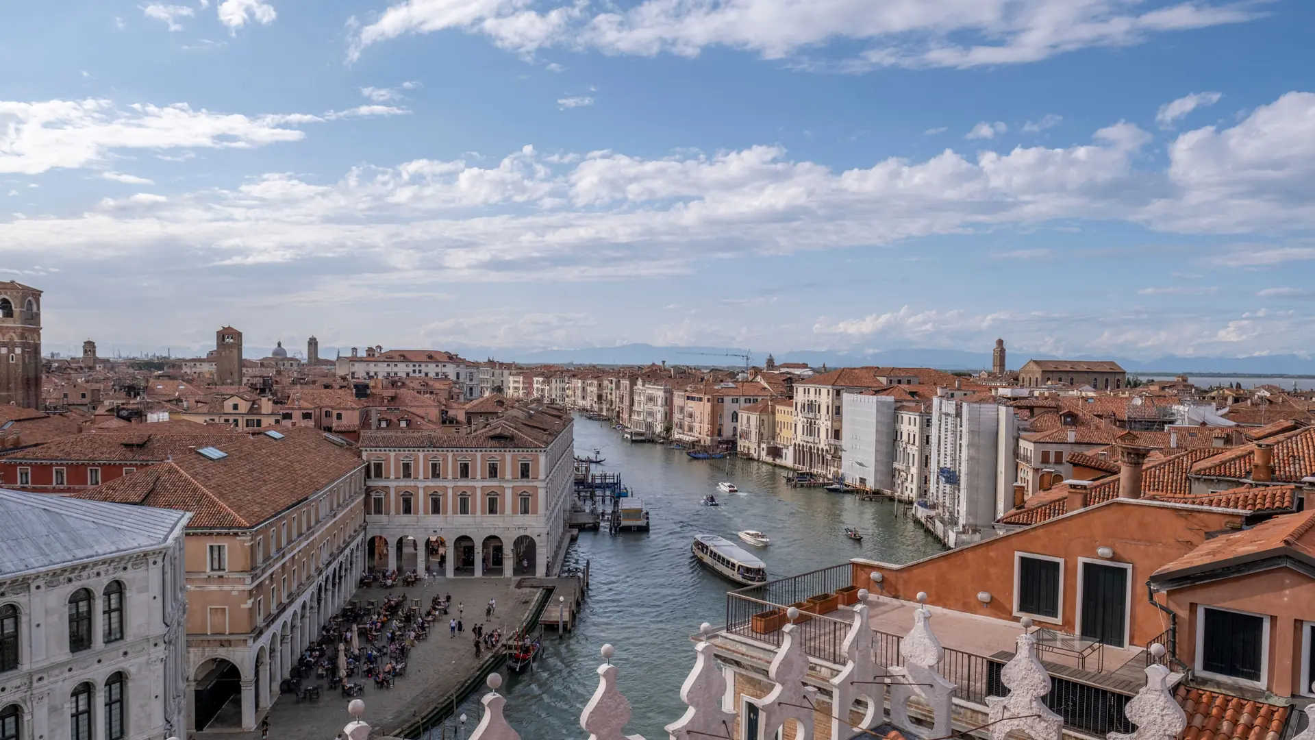 A bright aerial view of Venice canals, terracotta roofs and the lagoon