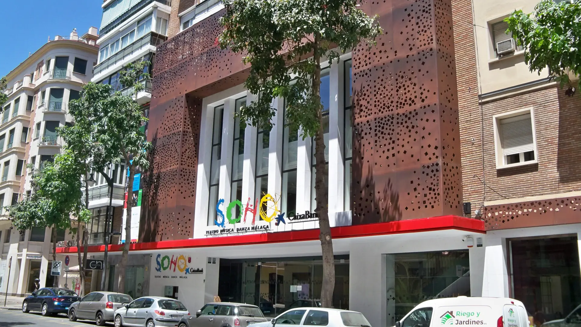 Perforated metal façade and colourful sign of Teatro del Soho in Málaga