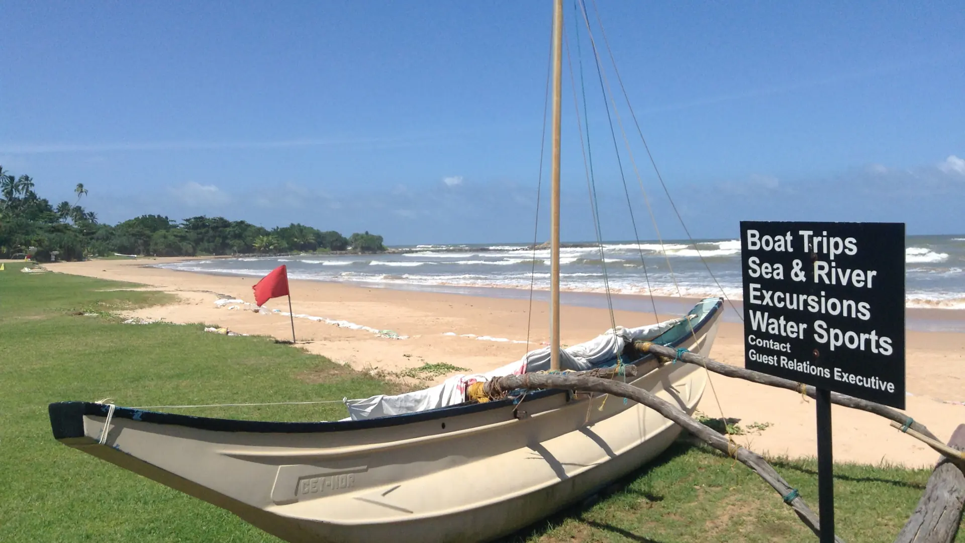 Outrigger boat by Bentota Beach under a clear blue sky