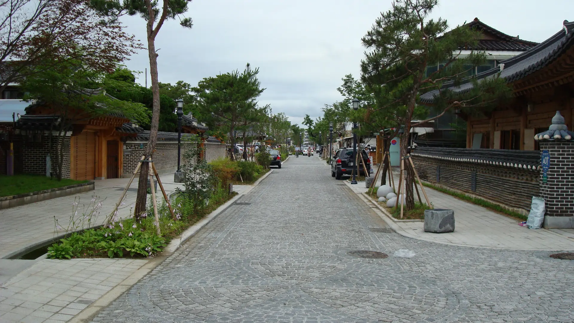 A bright, sunny cobblestone street in Jeonju Hanok Village lined with hanok buildings