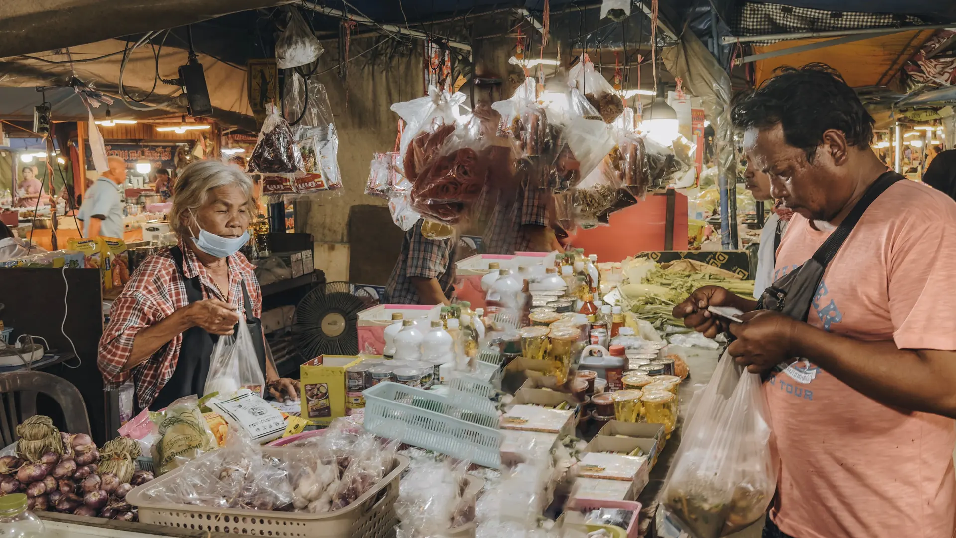 A vendor serving food from a busy Chiang Mai night-market stall