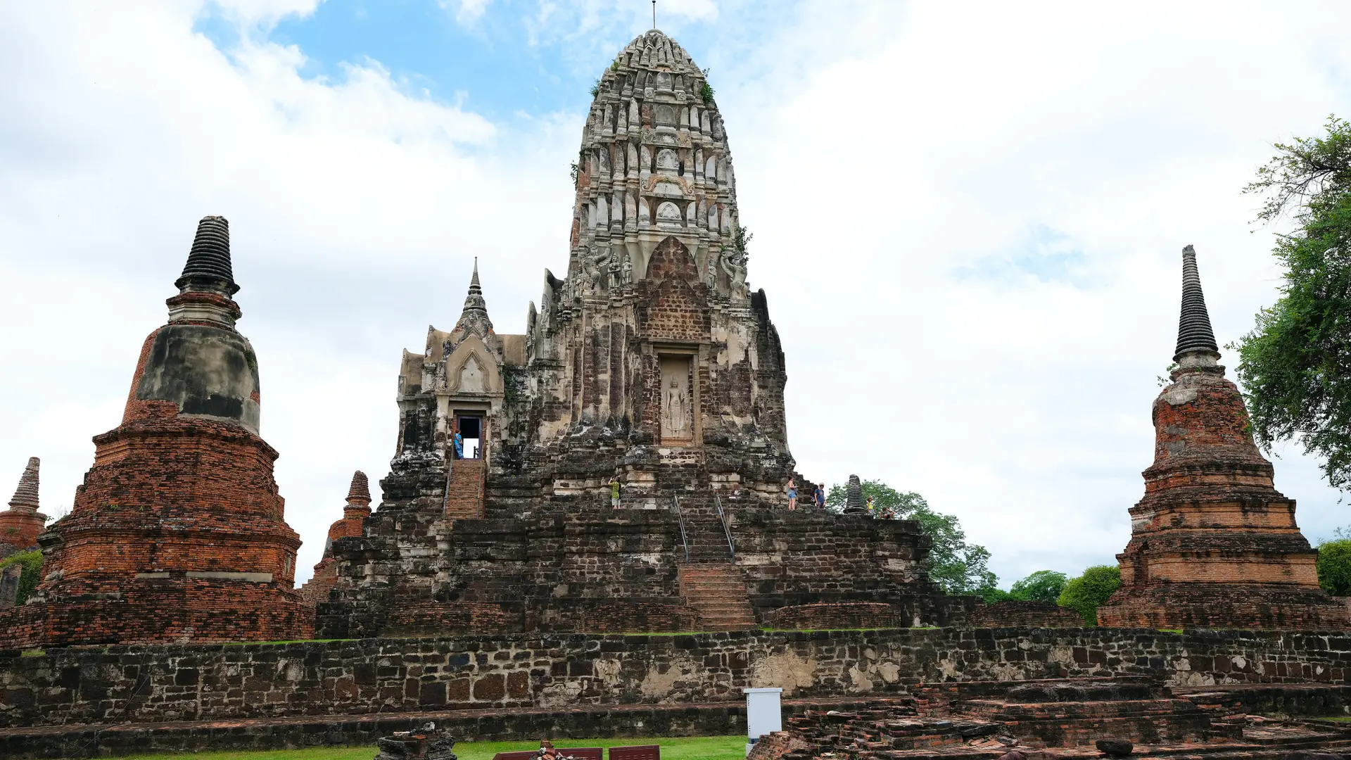 Sunlit brick ruins and a central prang in wider Ayutthaya, rather than Hua Ro