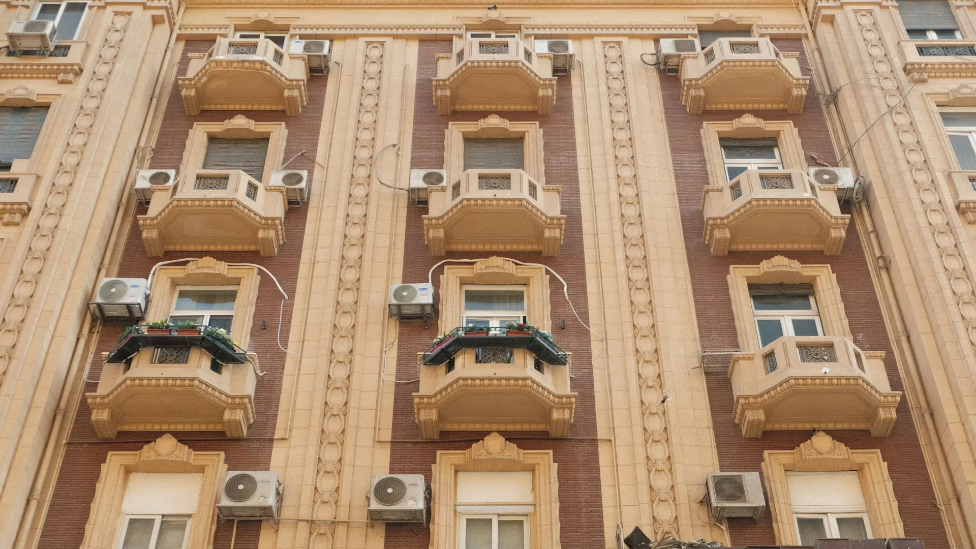 ornate stone balconies on a sunlit apartment facade in Bari