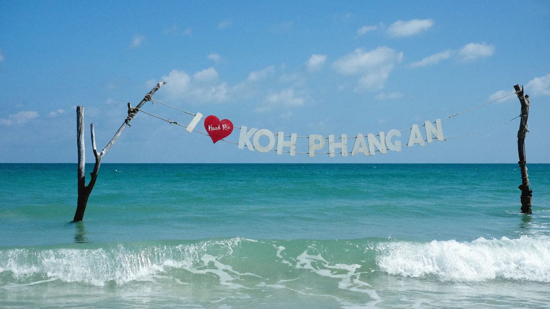 Rolling Gulf waves breaking onto Koh Phangan's pale sand