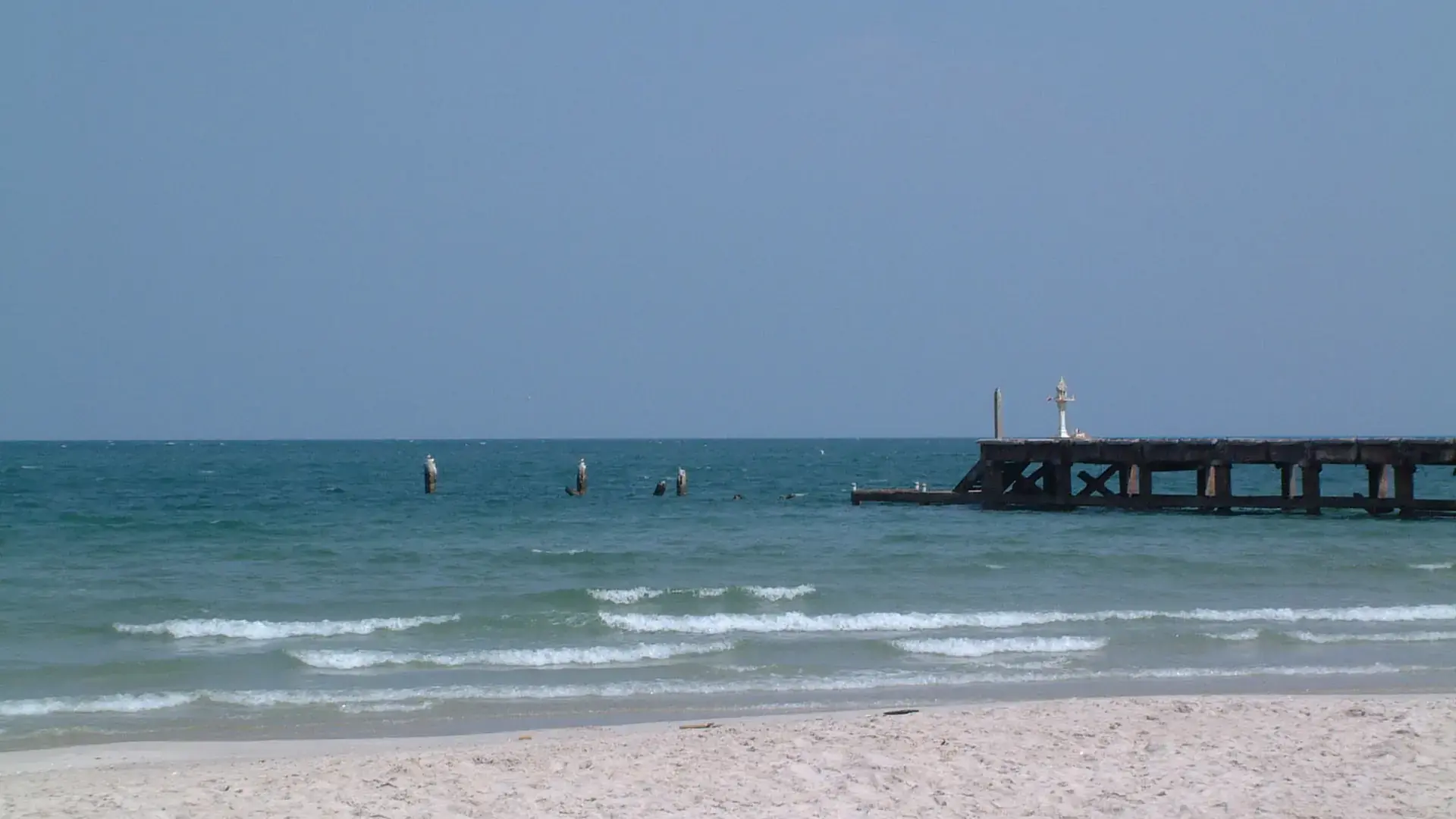 Blue sea and sandy shoreline in central Hua Hin, shown as a wider coastal scene