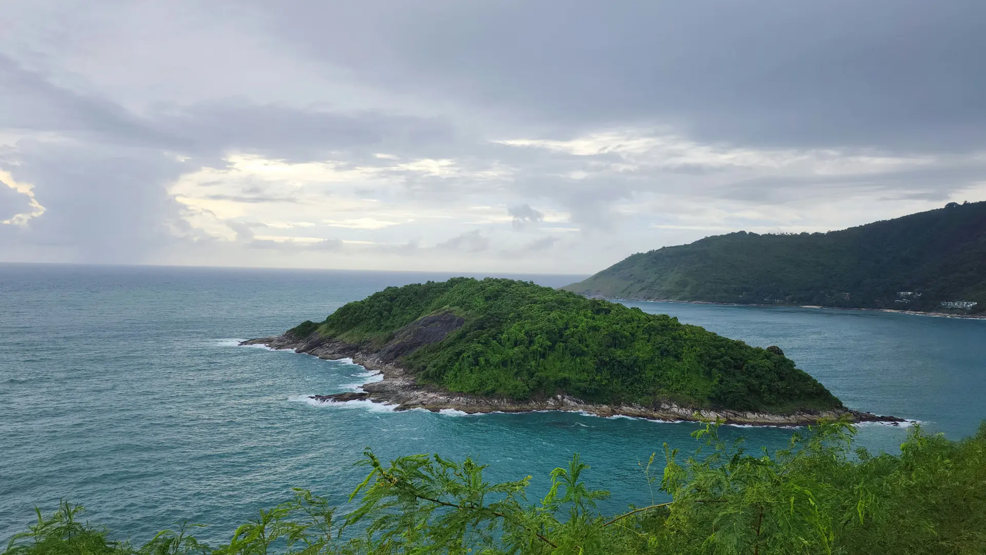 Green Promthep Cape reaching into turquoise water at Phuket's southern tip