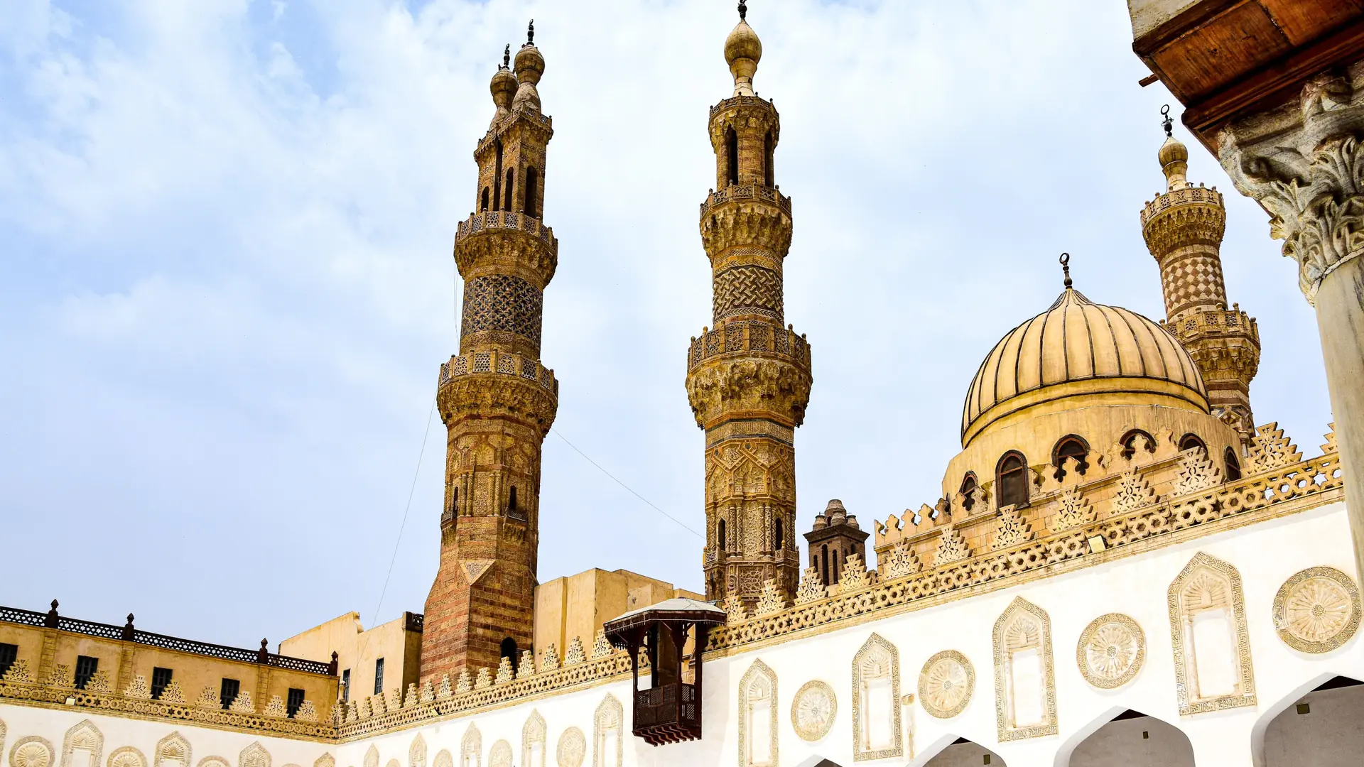 Sunlit domes and minarets above Al-Azhar Mosque’s courtyard in Cairo.