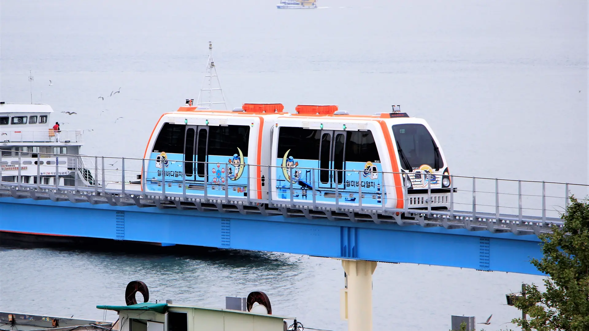 The Wolmi Sea Train monorail marked '월미바다열차' crossing an elevated track over the water at Wolmido, Incheon, in daylight