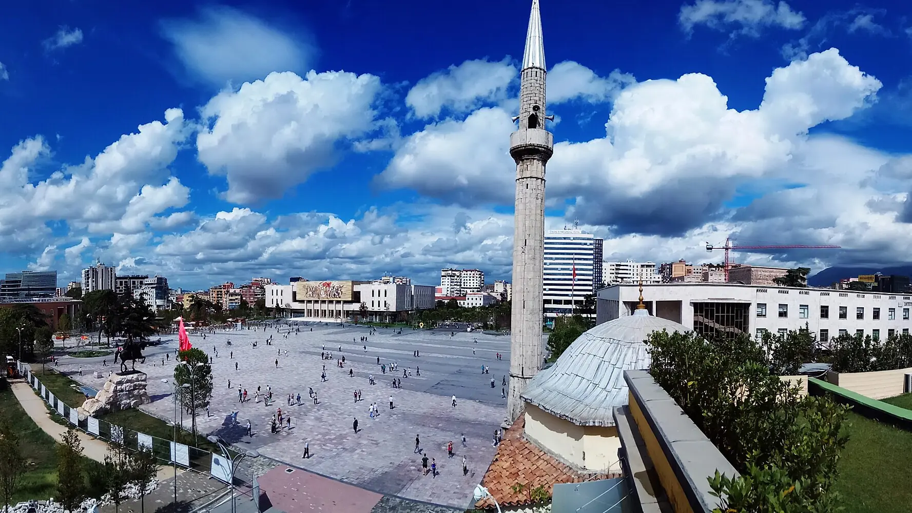 Panorama over Skanderbeg Square in Tirana, with the Et'hem Bey Mosque and clock tower under a blue sky