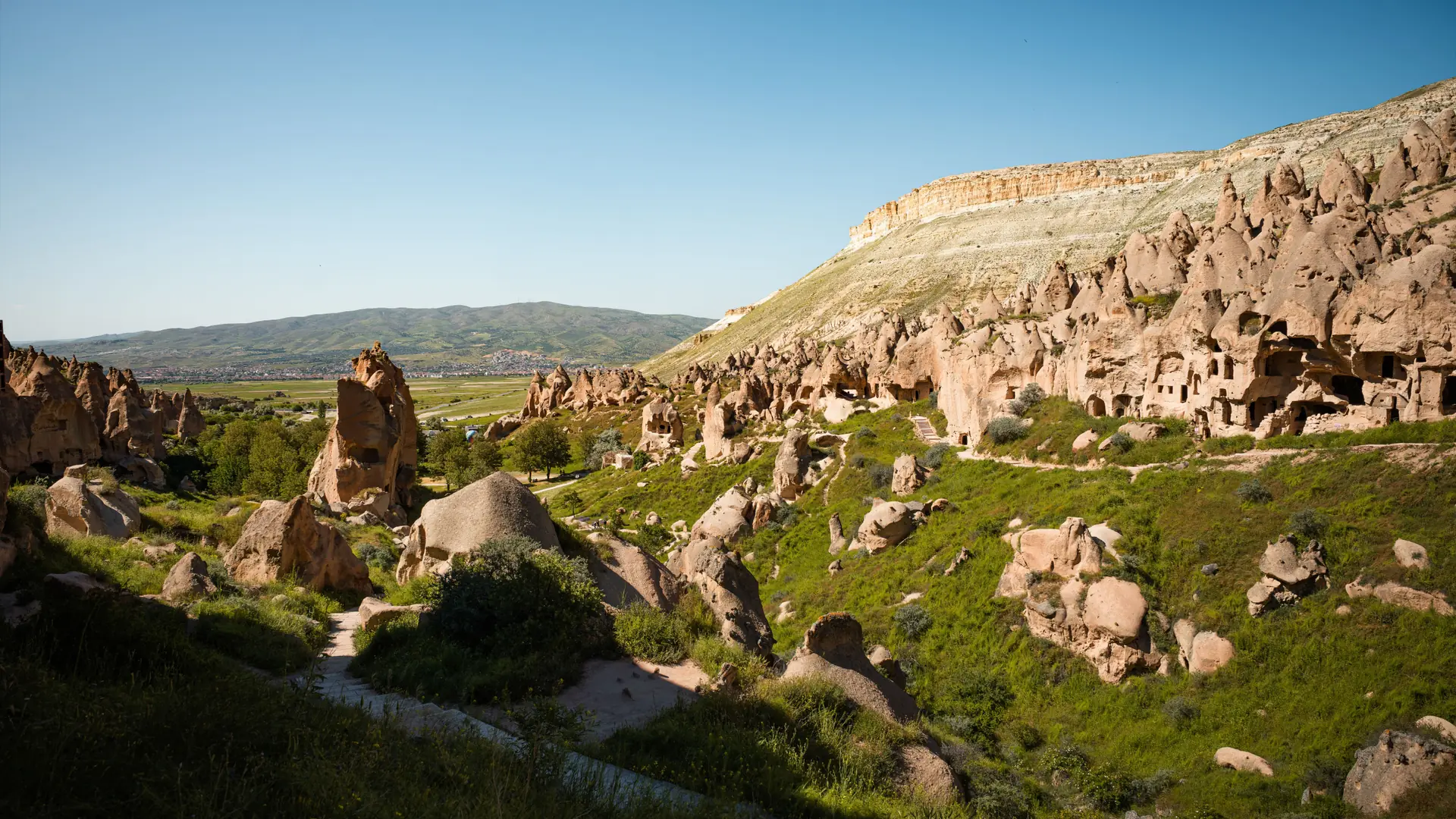 Green valley and sculpted volcanic rock formations in Nevşehir