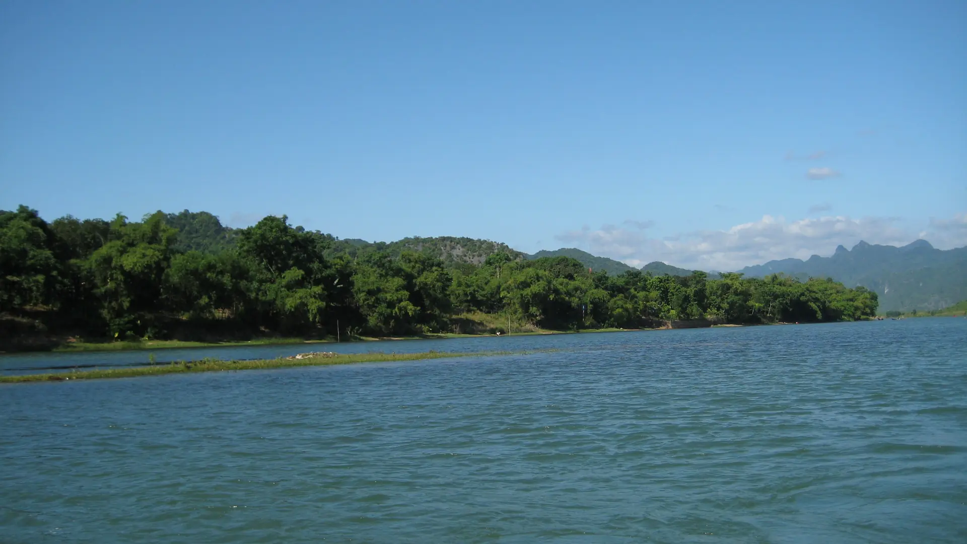 The Son River and green limestone slopes in the wider Phong Nha-Ke Bang region, not a photograph of Chay Lap accommodation