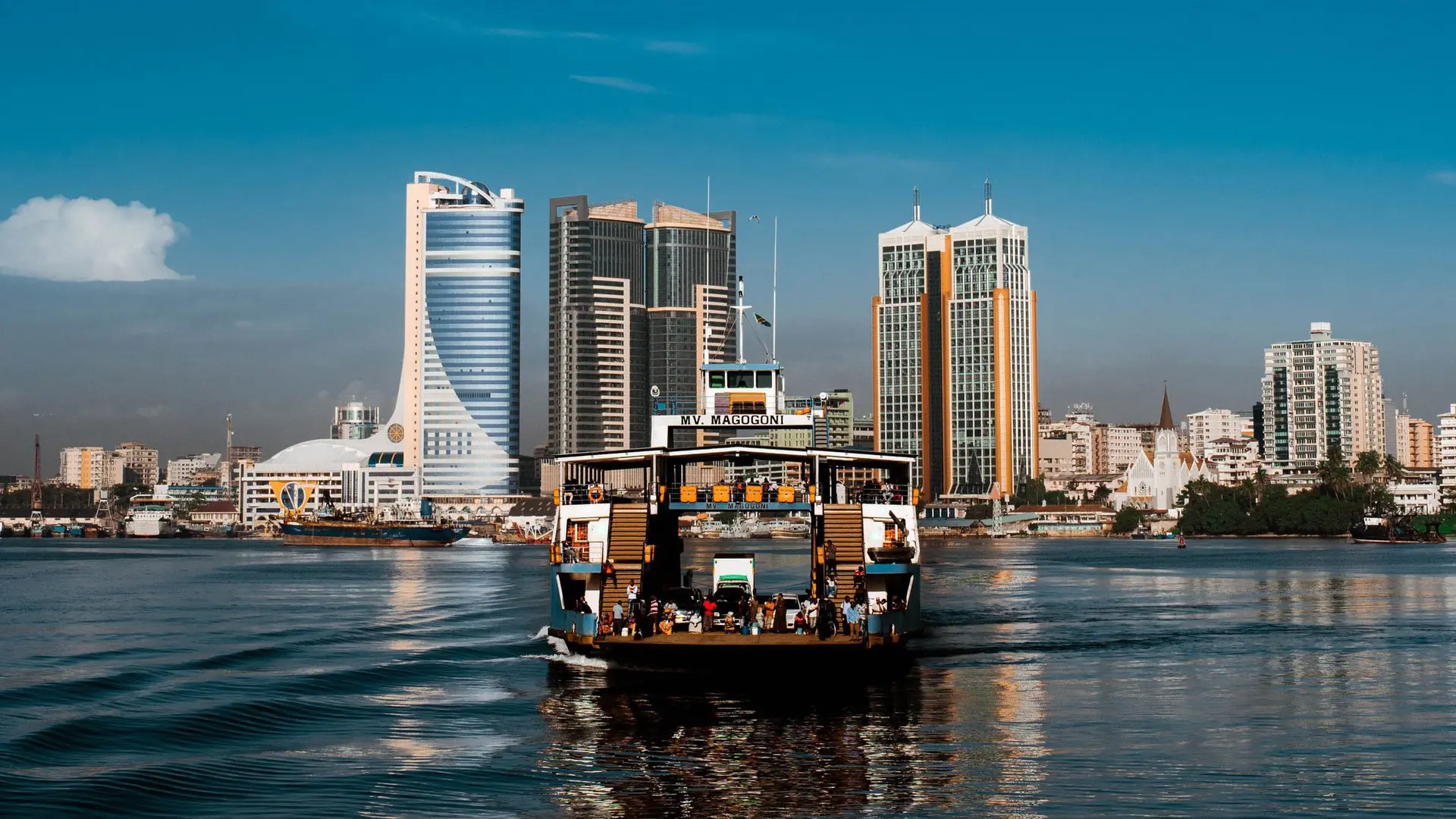 Dar es Salaam skyline and passenger boat on blue water in daylight