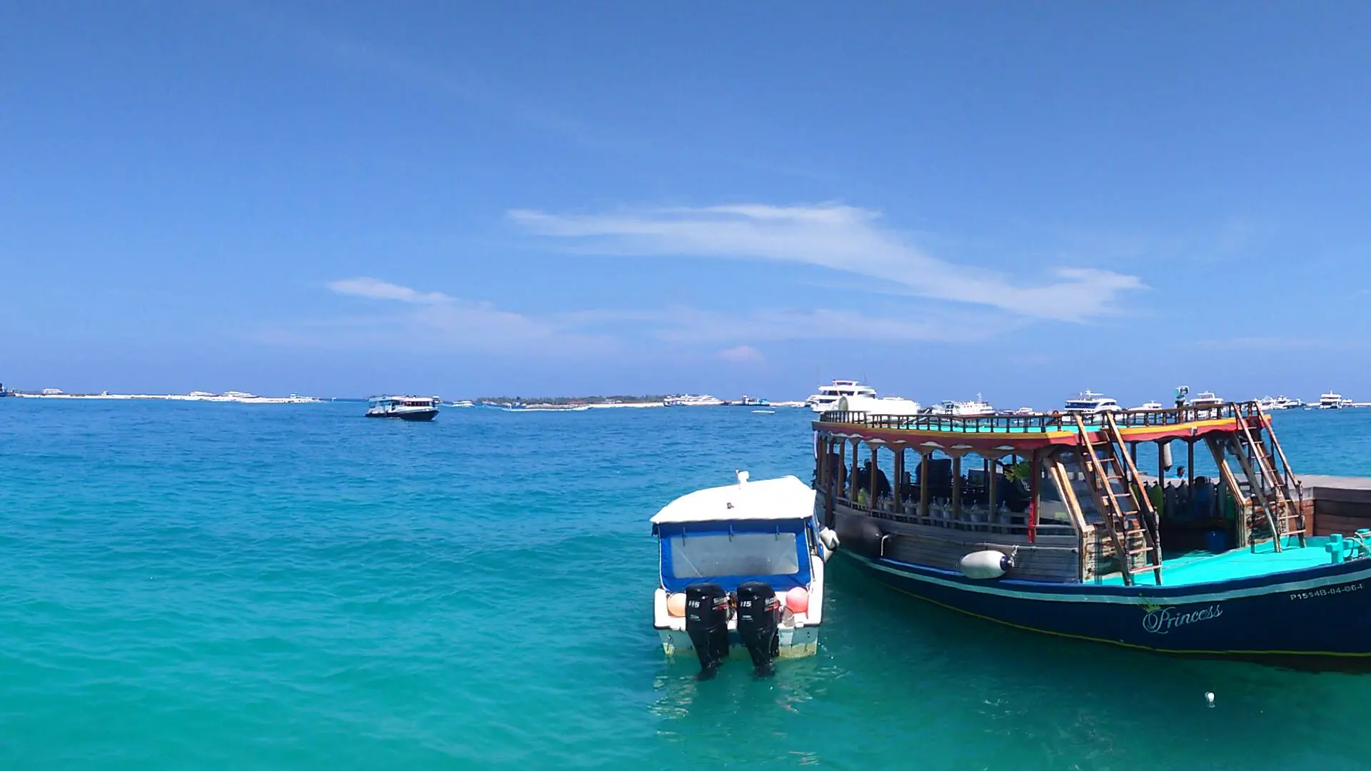 Sunny Hulhumalé ferry terminal above blue water with passenger boats