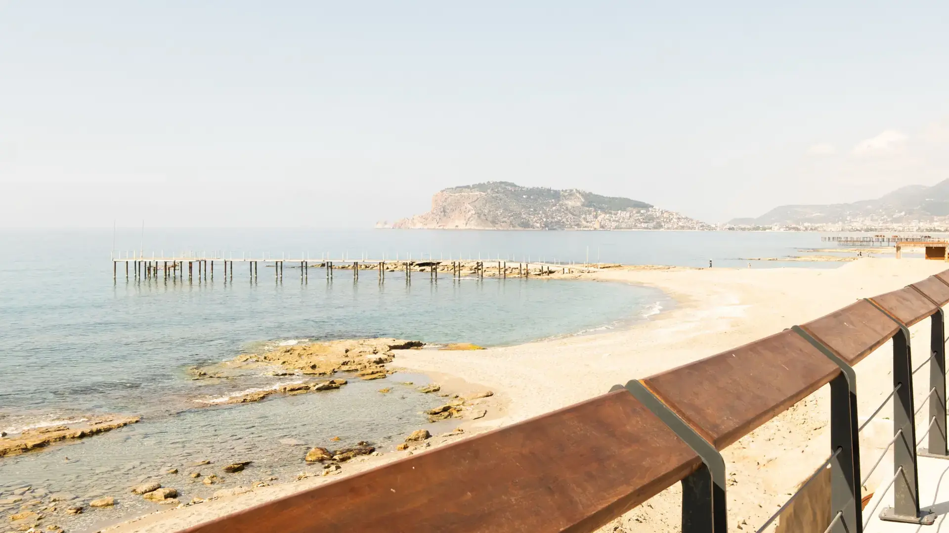 Sunny Alanya beachfront with calm Mediterranean water and an open coastal promenade