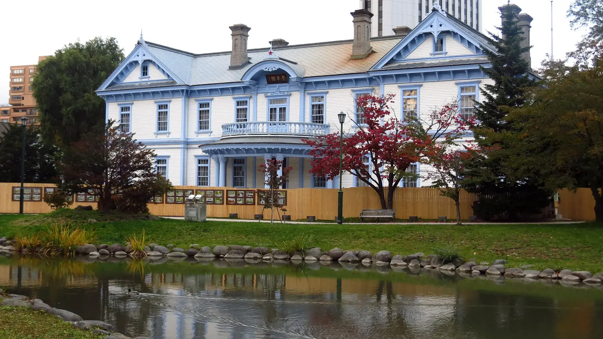 historic white Hoheikan beside the pond and autumn trees in Nakajima Park
