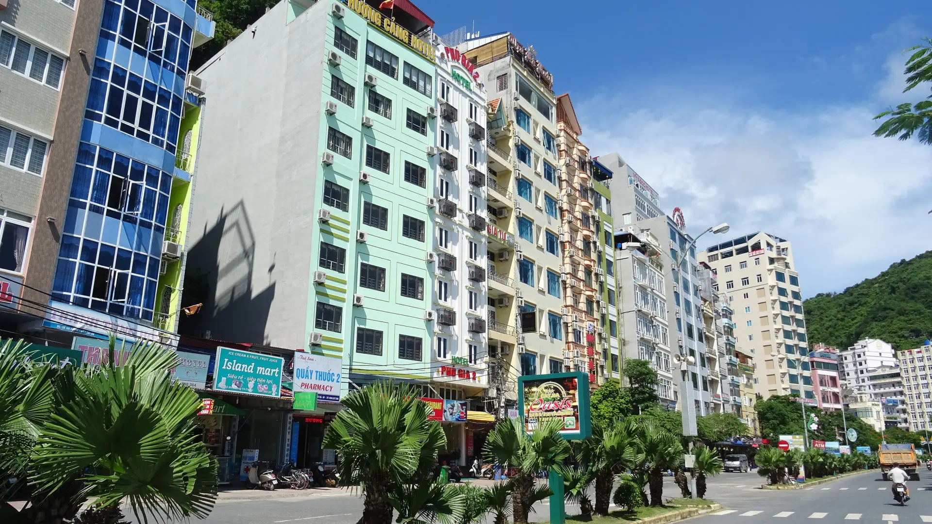 Sunlit hotel and shop facades on a visitor street in Cat Ba town
