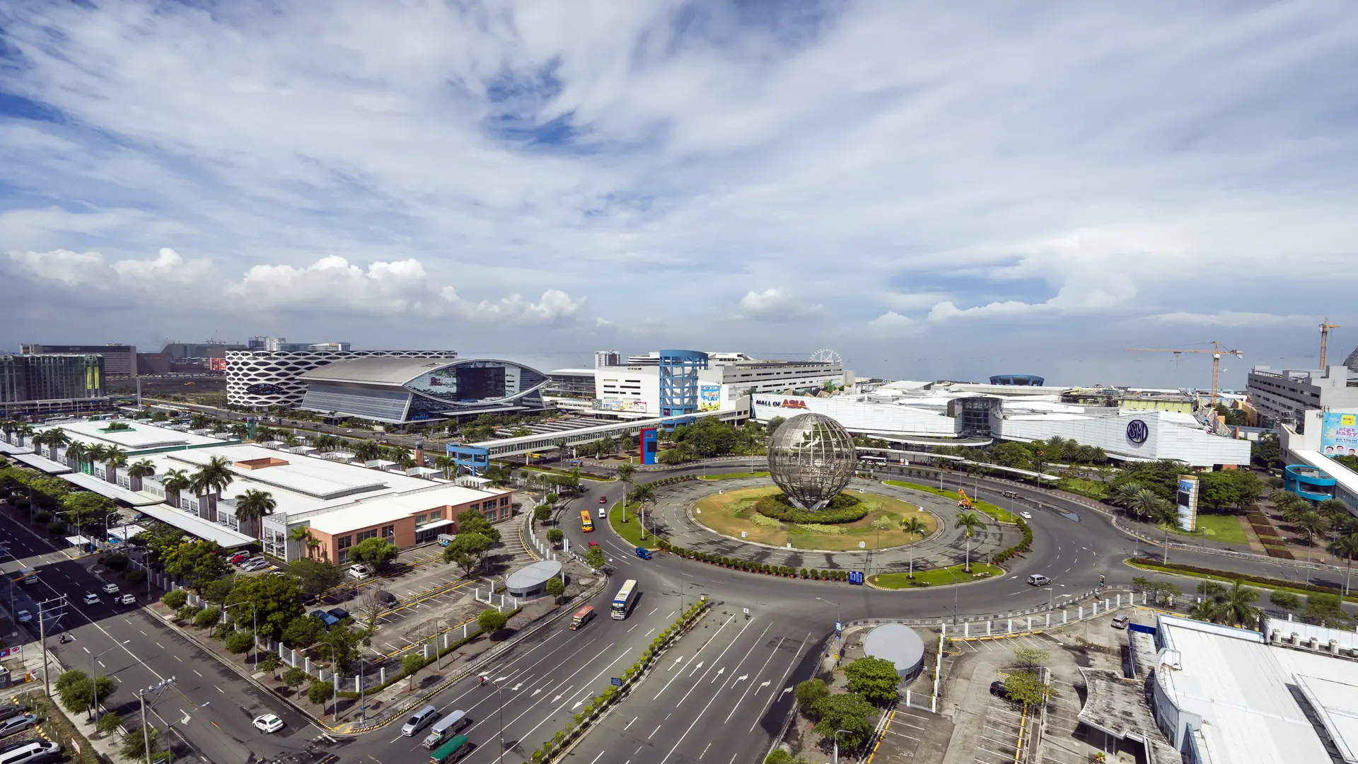 The Mall of Asia globe, shopping complex and arena across Pasay’s broad roads in daylight