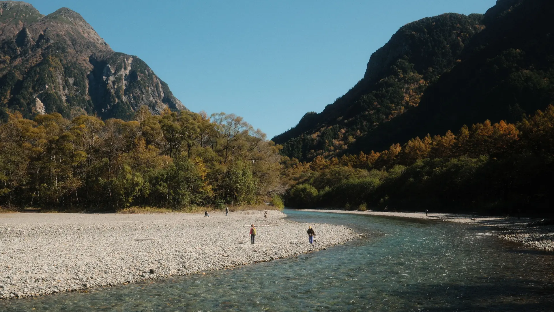 Kamikochi river reflecting forest and Japanese Alps peaks in clear autumn light