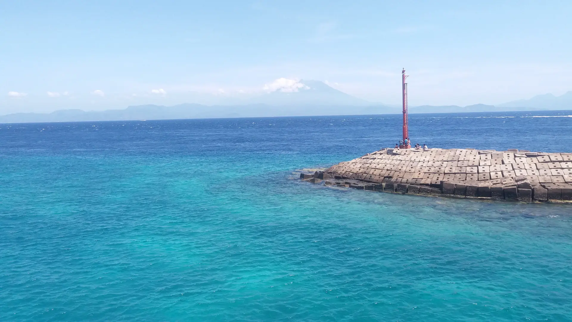 Blue water and Mount Agung seen from Buyuk harbour on the wider Nusa Penida north coast