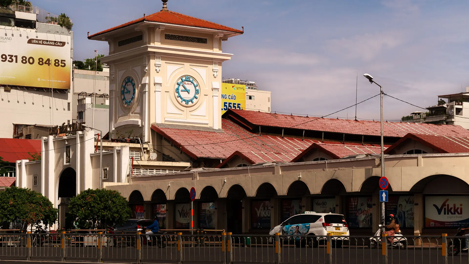 Ben Thanh Market clock tower and red roofs in daylight