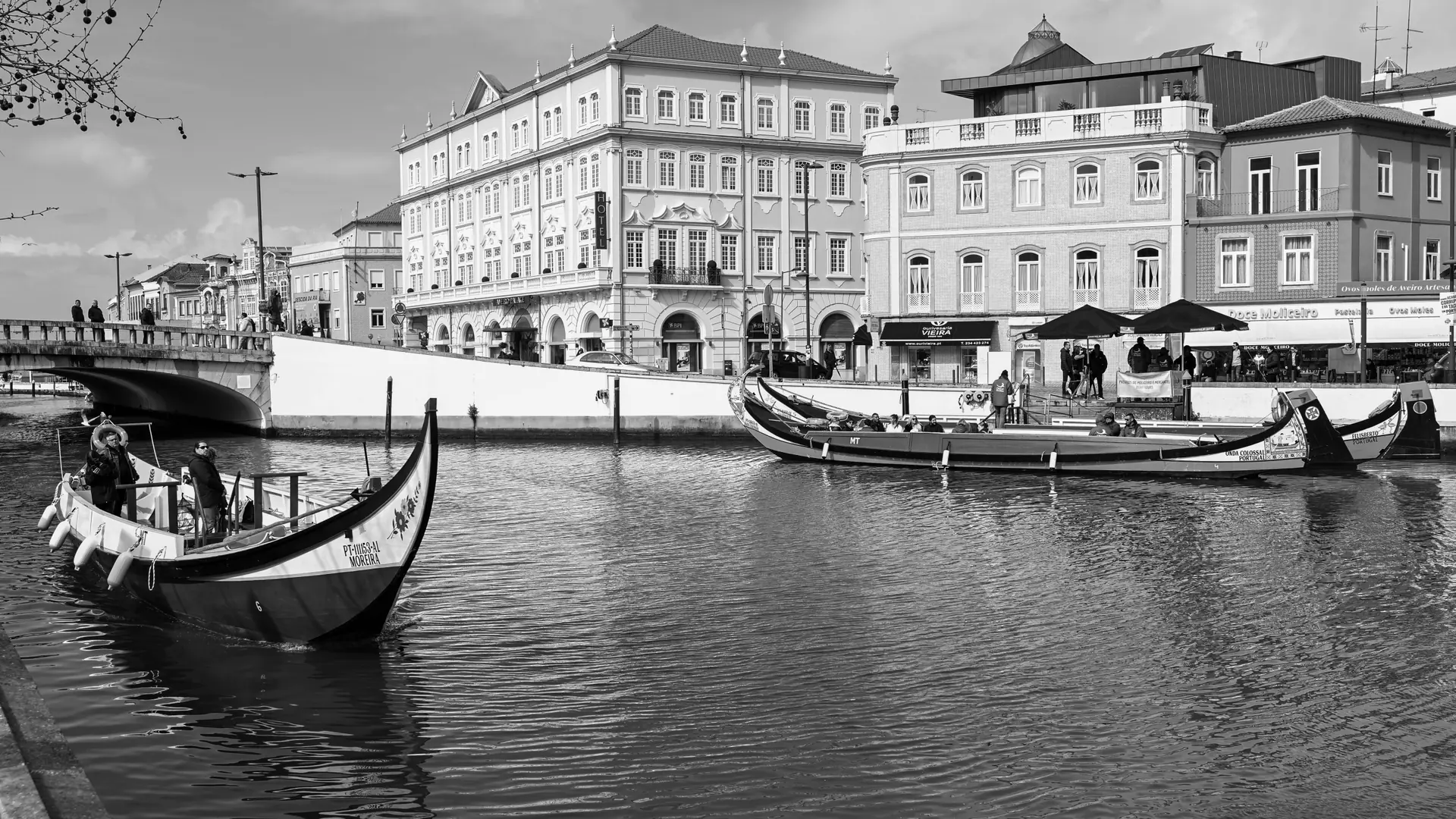 Black-and-white view of moliceiro boats and historic buildings on an Aveiro canal