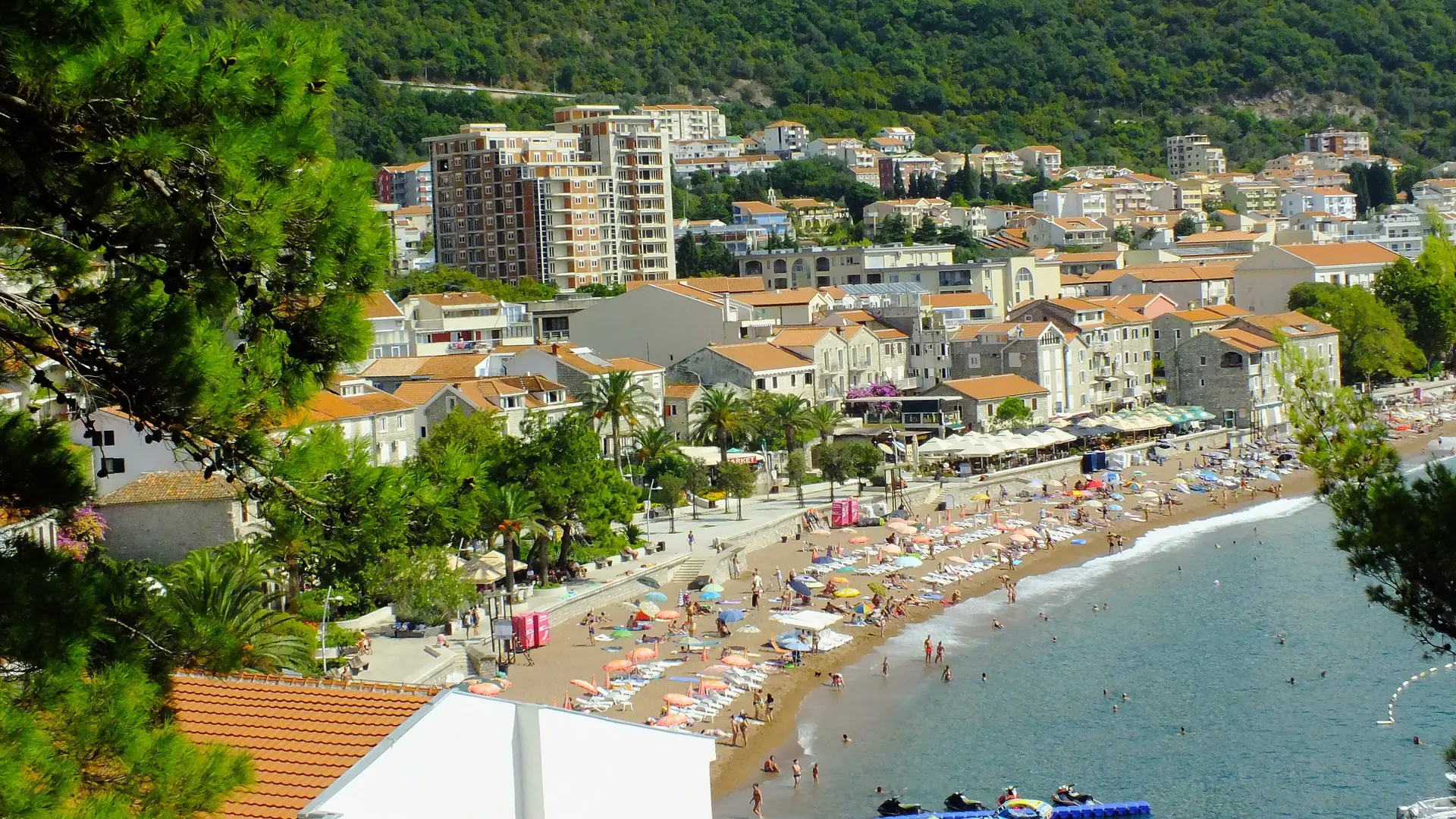 Sunny Petrovac town beach and seafront promenade