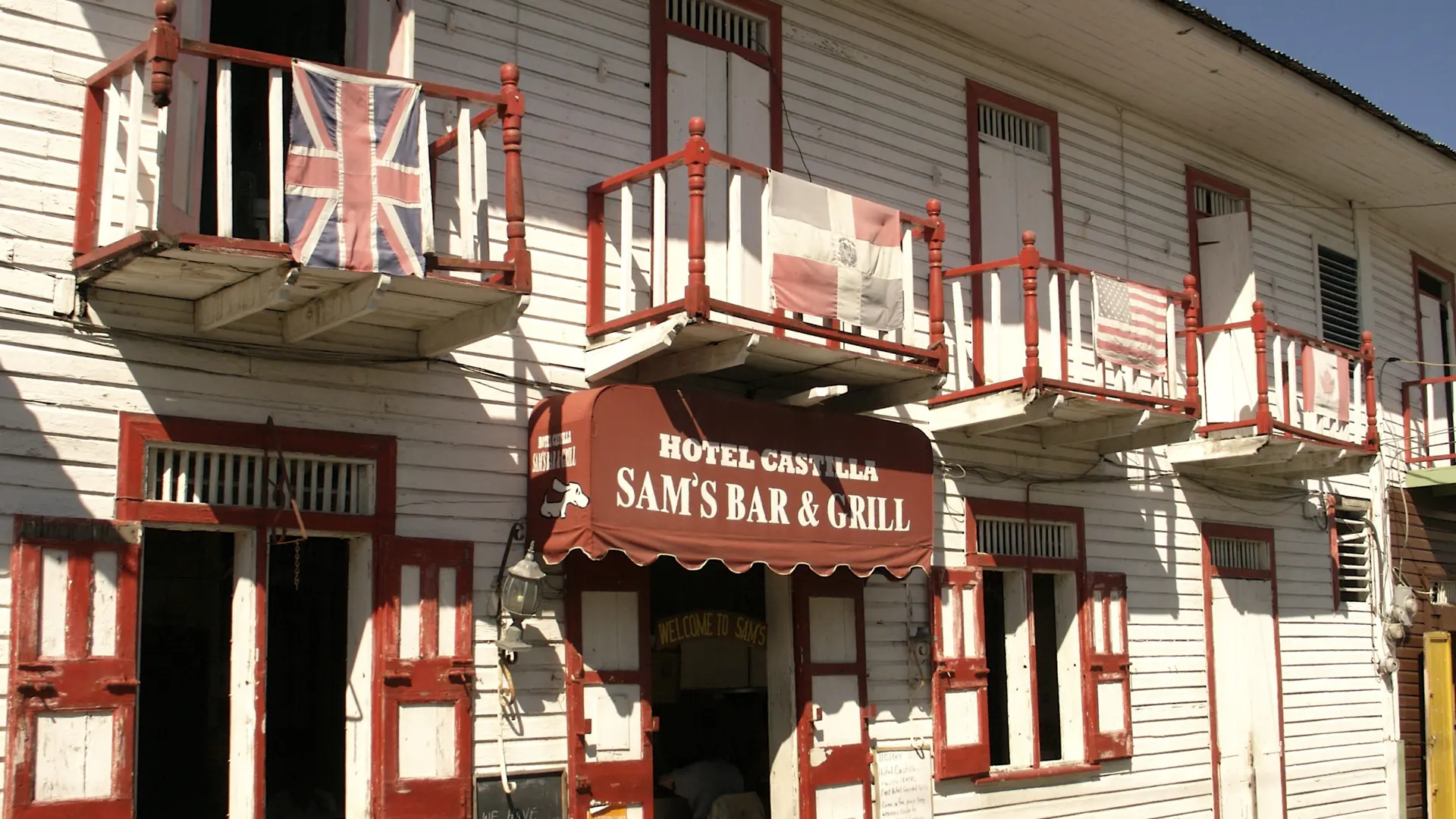 Sunlit white-and-red hotel facade in central Puerto Plata