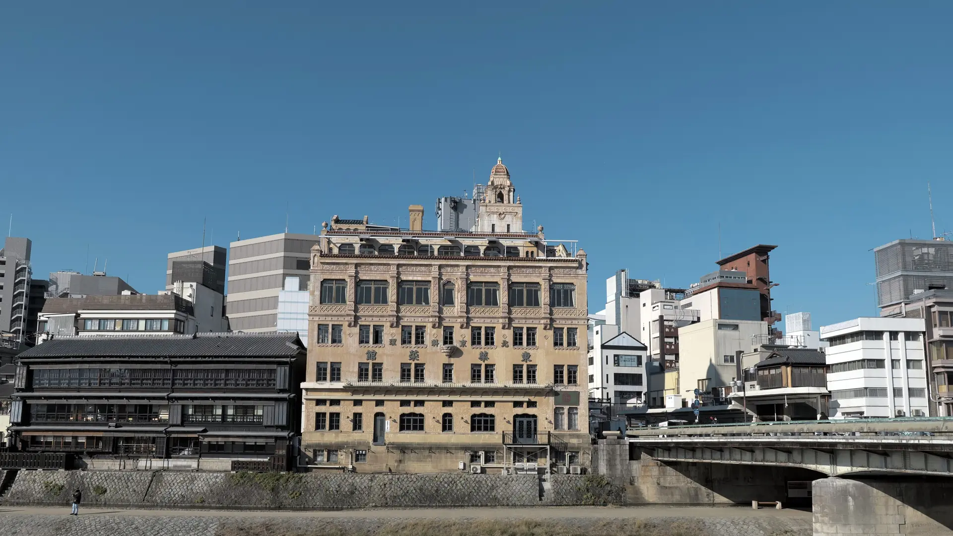 Tohkasaikan's ornate facade beside Shijo Bridge and the Kamo River in Kyoto.