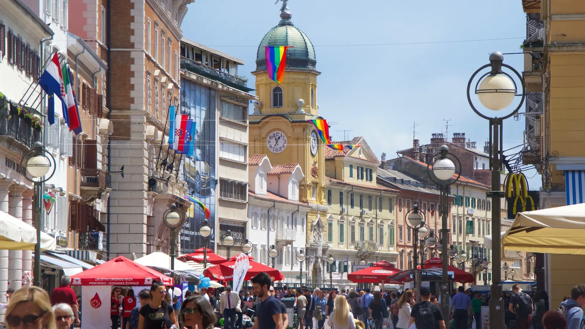 The City Tower, flags and pedestrians on Rijeka’s Korzo
