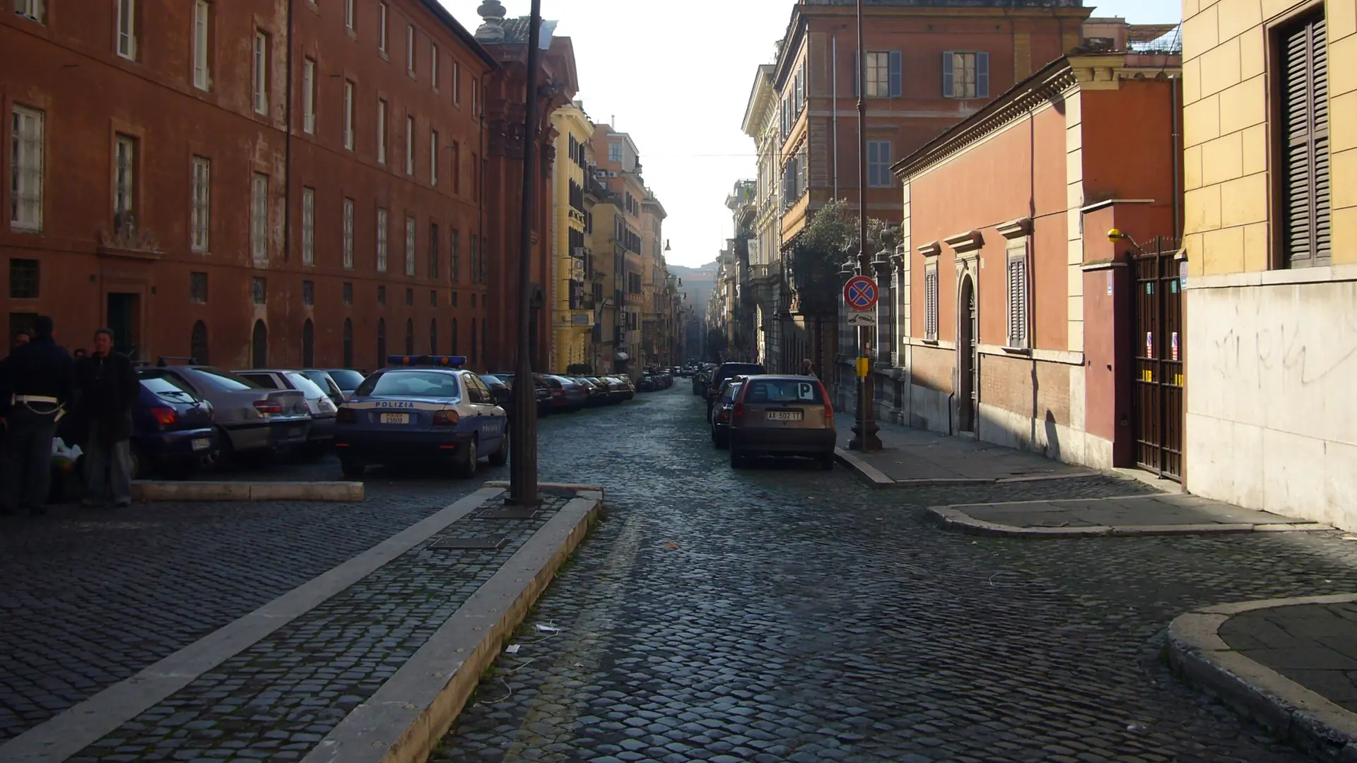 a sunlit cobbled street lined with warm-toned townhouses in Monti, Rome