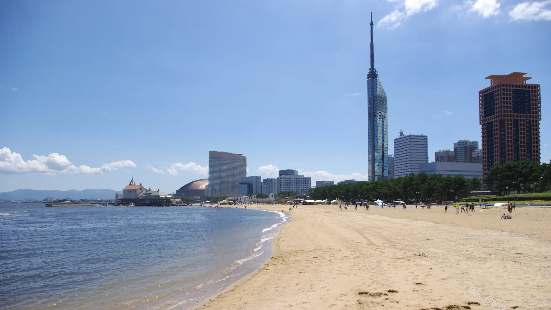 Fukuoka Tower and the bright blue waters of Hakata Bay beneath a clear sky