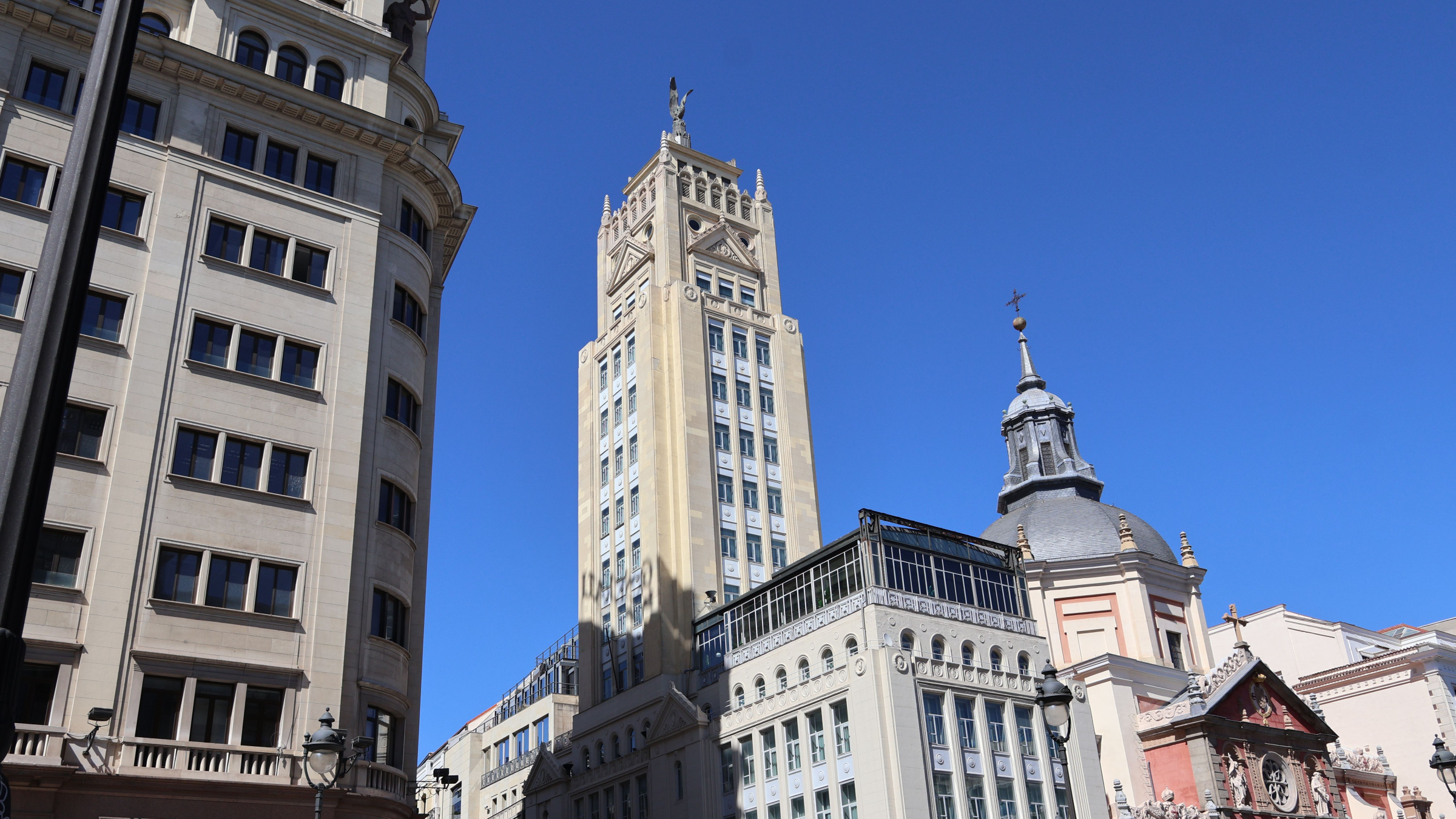 Calatravas Church and a neighbouring tower on Calle de Alcalá in Madrid under a clear blue sky