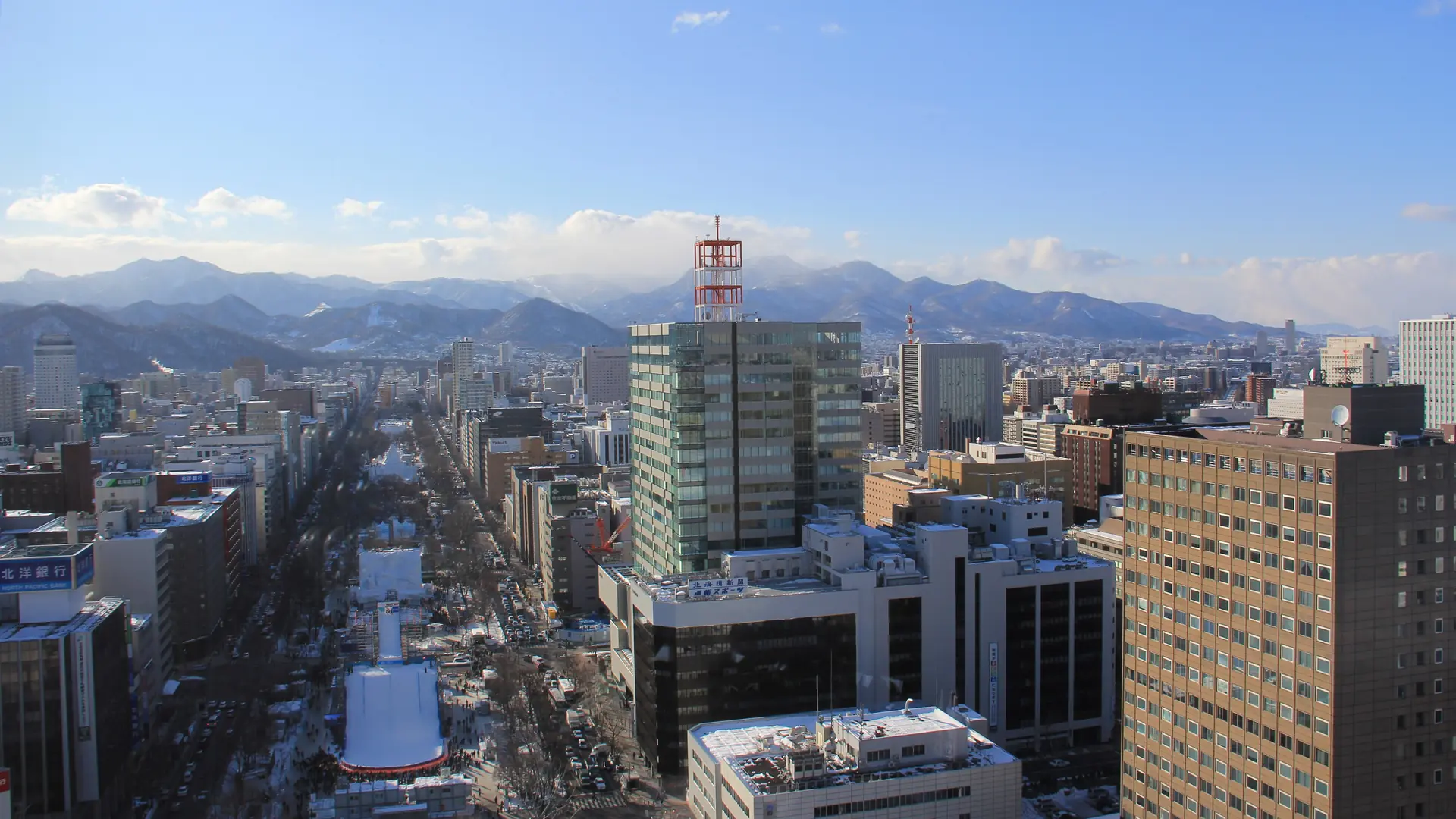 Snow-covered Odori Park and central Sapporo beneath a clear daytime sky