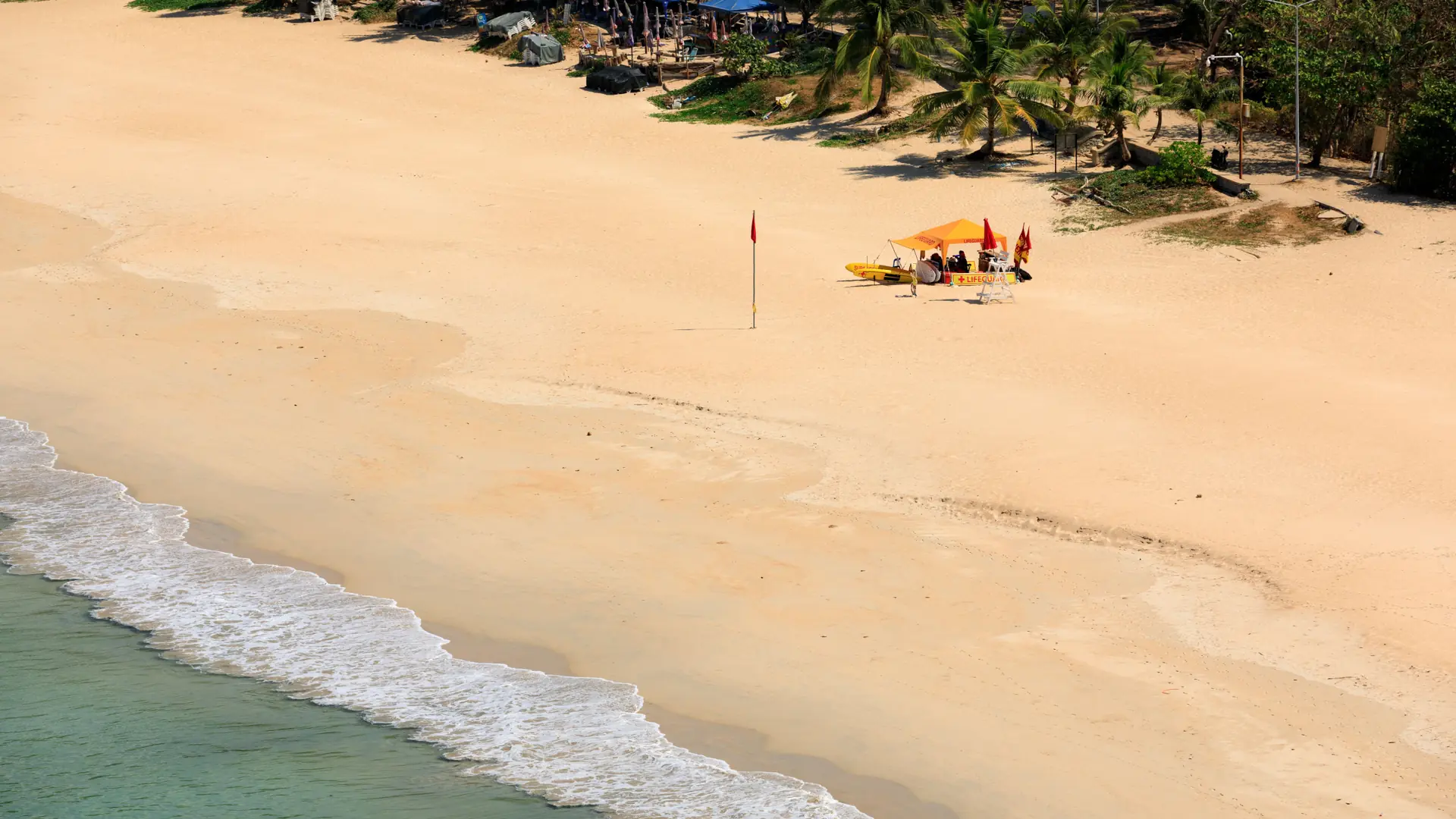 Kamala Beach's golden arc and green Phuket hills seen from above