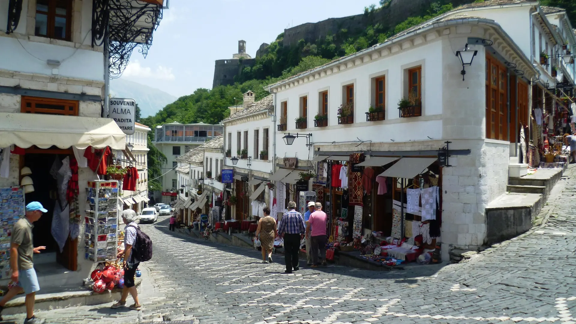 Souvenir shops on a cobbled street in Gjirokastër's old bazaar below the castle