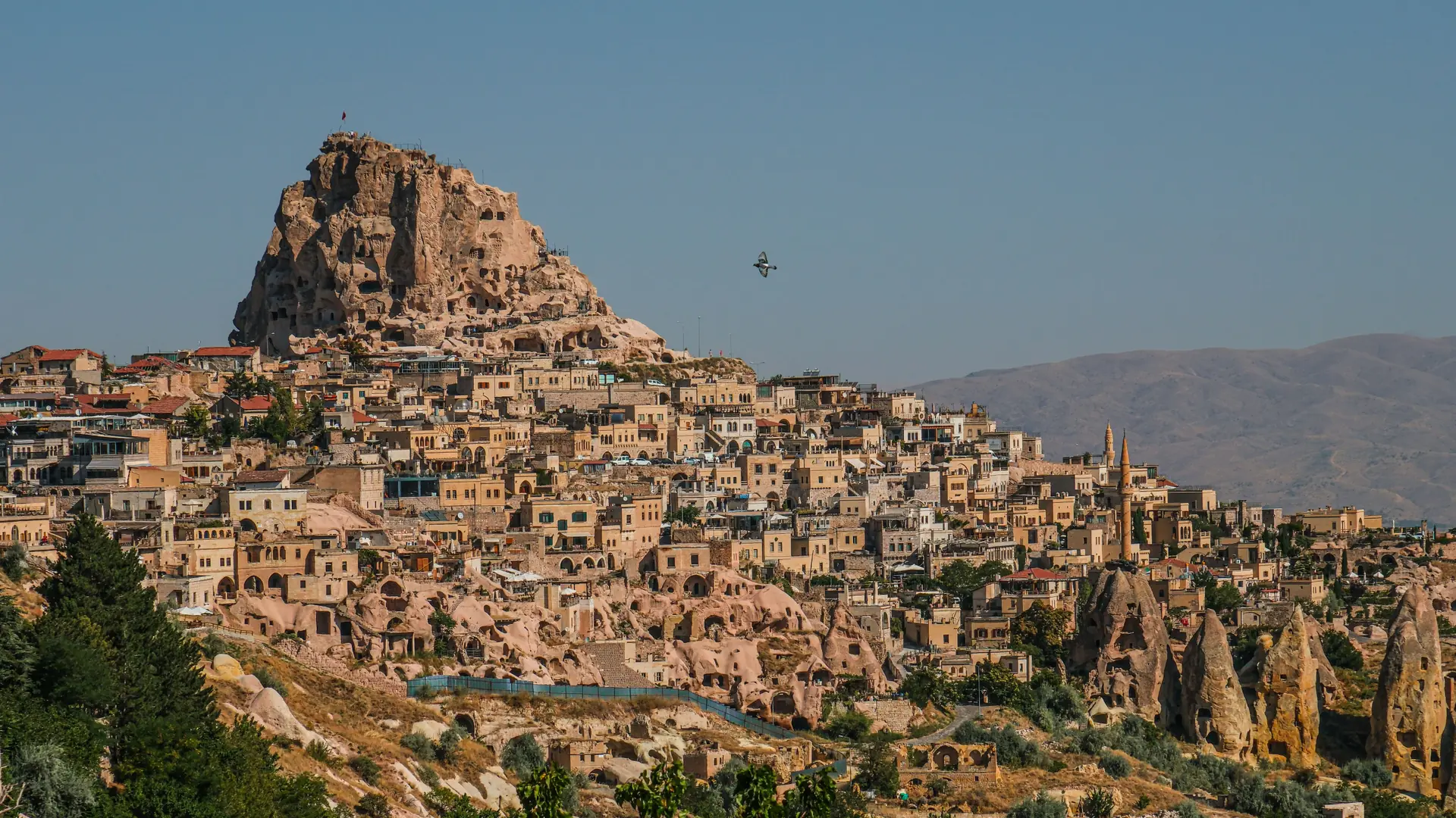 Uçhisar Castle rock and Cappadocia valleys in crisp golden daylight