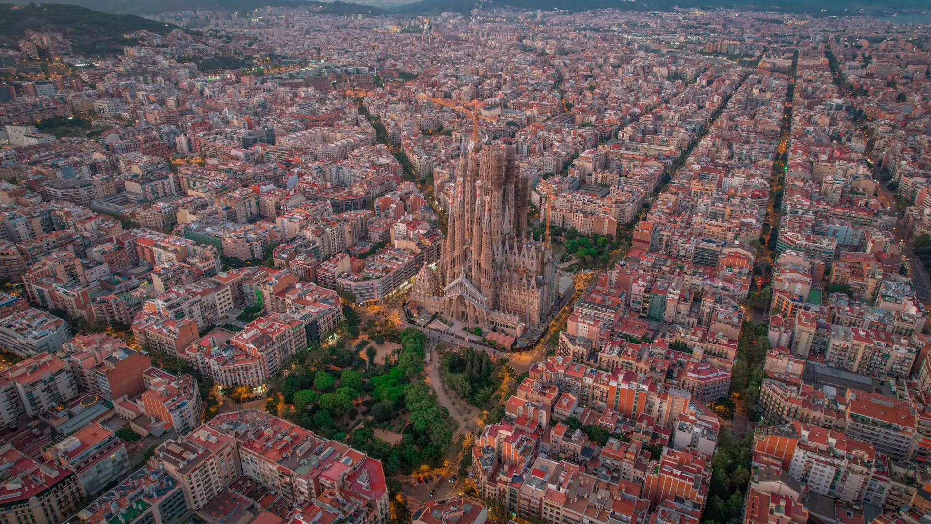 Oblique aerial view of the Sagrada Família rising above Barcelona’s Eixample streets