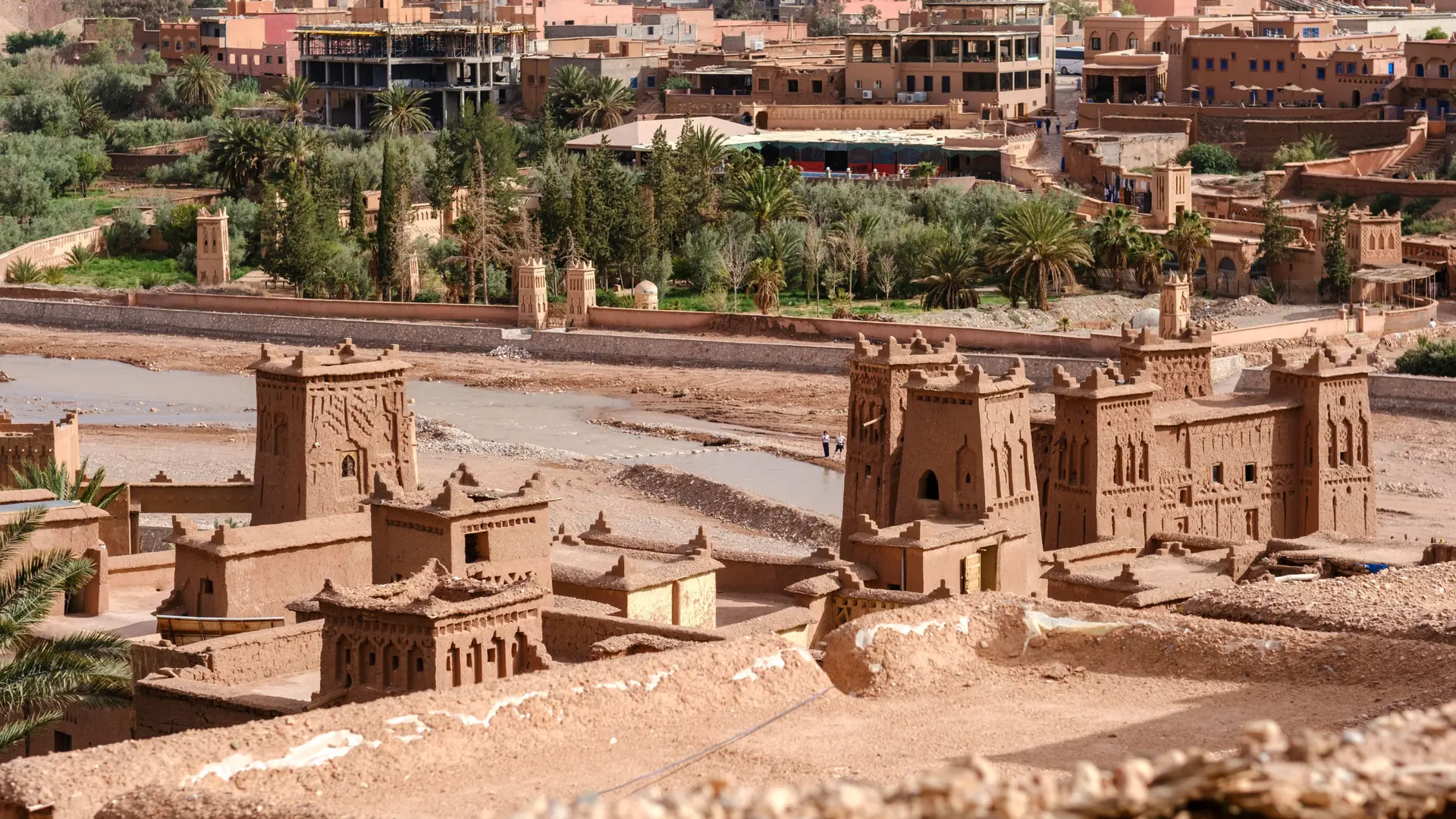 Earthen towers and palm trees beside Aït Benhaddou, Morocco