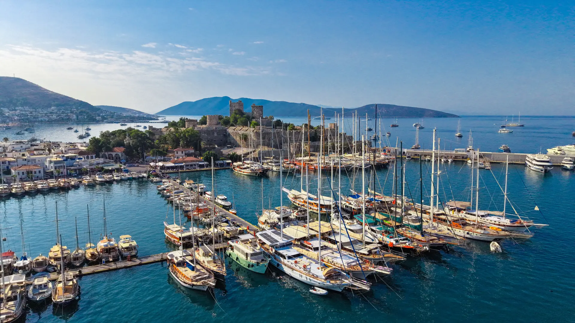 Bodrum Castle and sailing yachts in the central marina under a bright blue sky