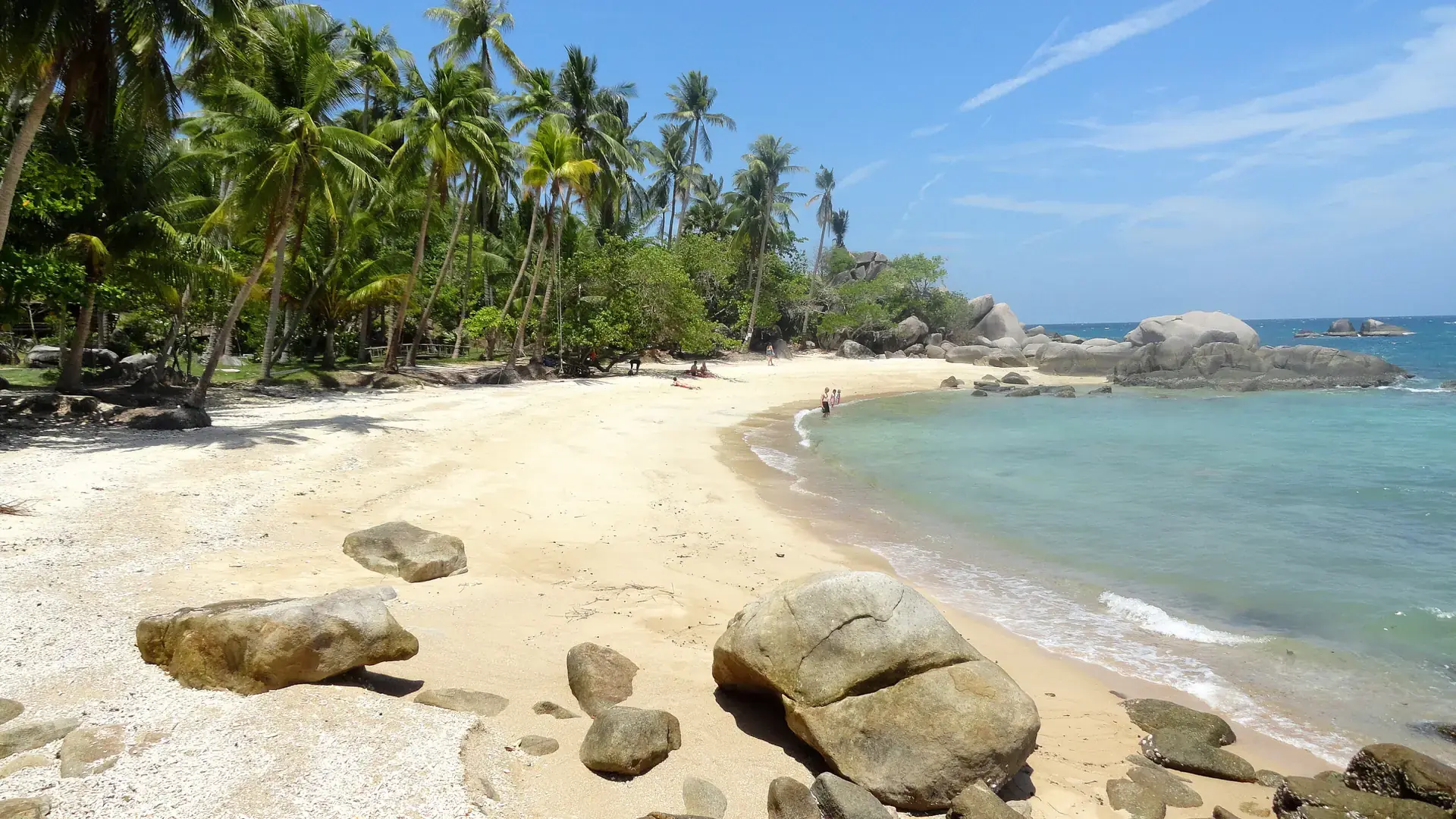 Palms, granite boulders and sandy shore at Sai Nuan Beach on Koh Tao