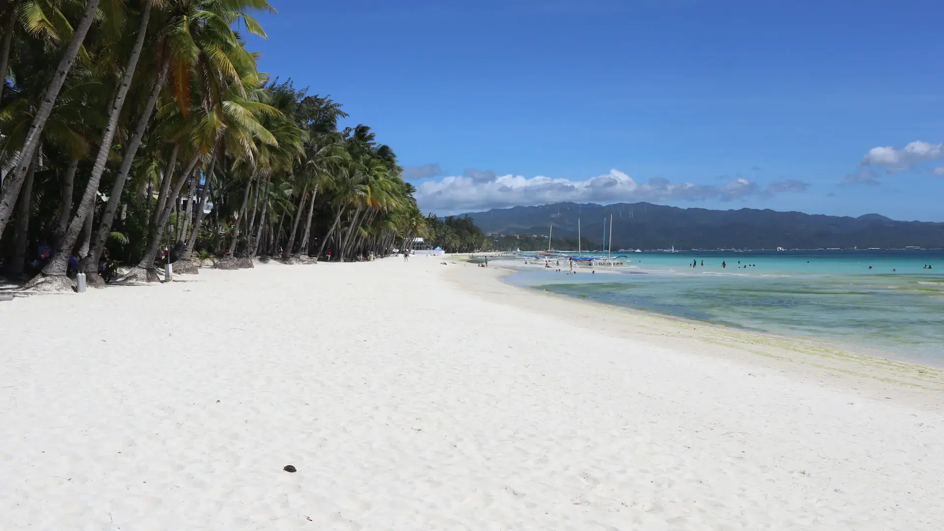Powder-white sand and palms along Boracay's White Beach on a bright day