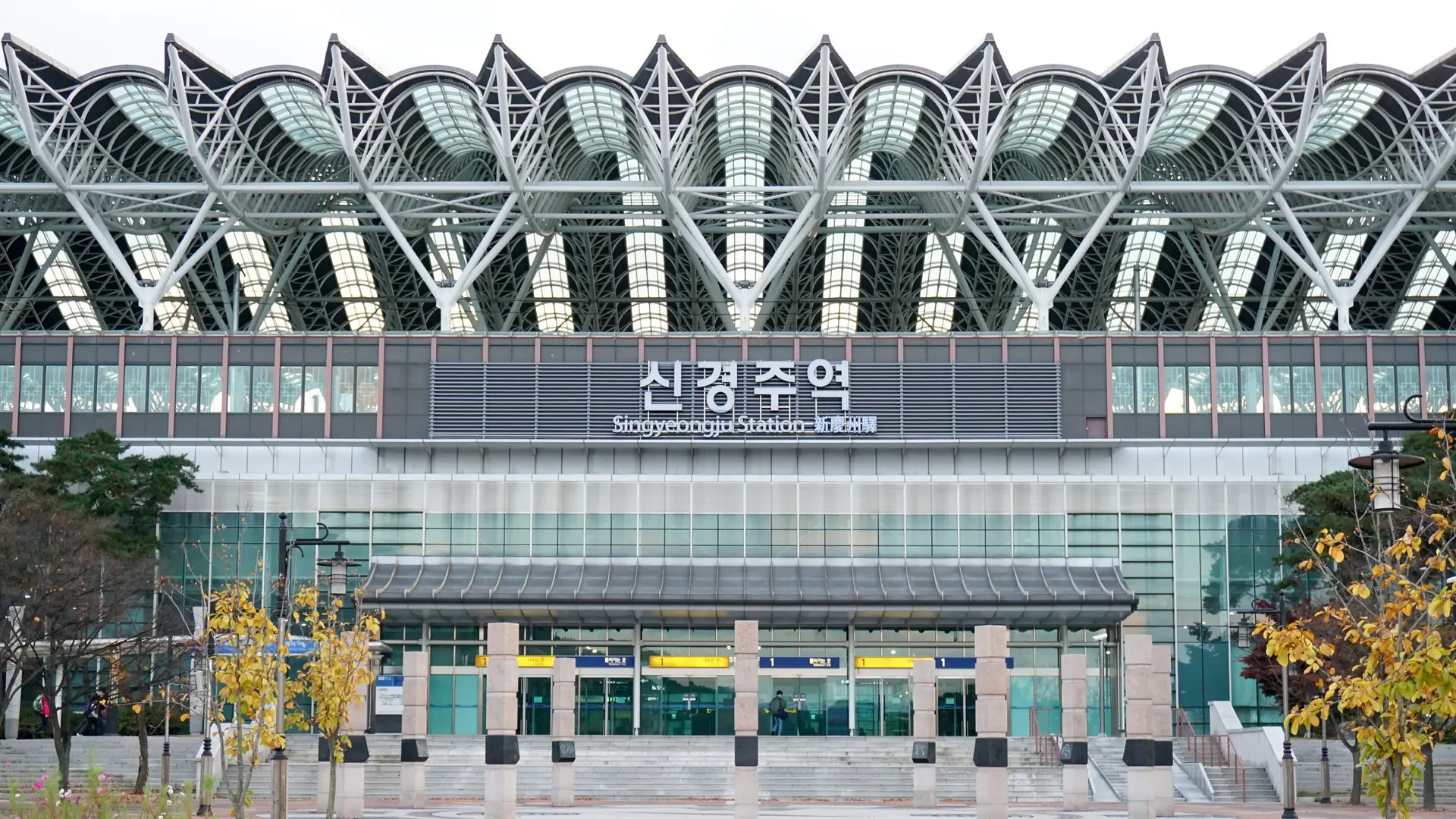 The KTX station's distinctive glass-and-steel exterior, with its former Singyeongju signage, in bright daylight