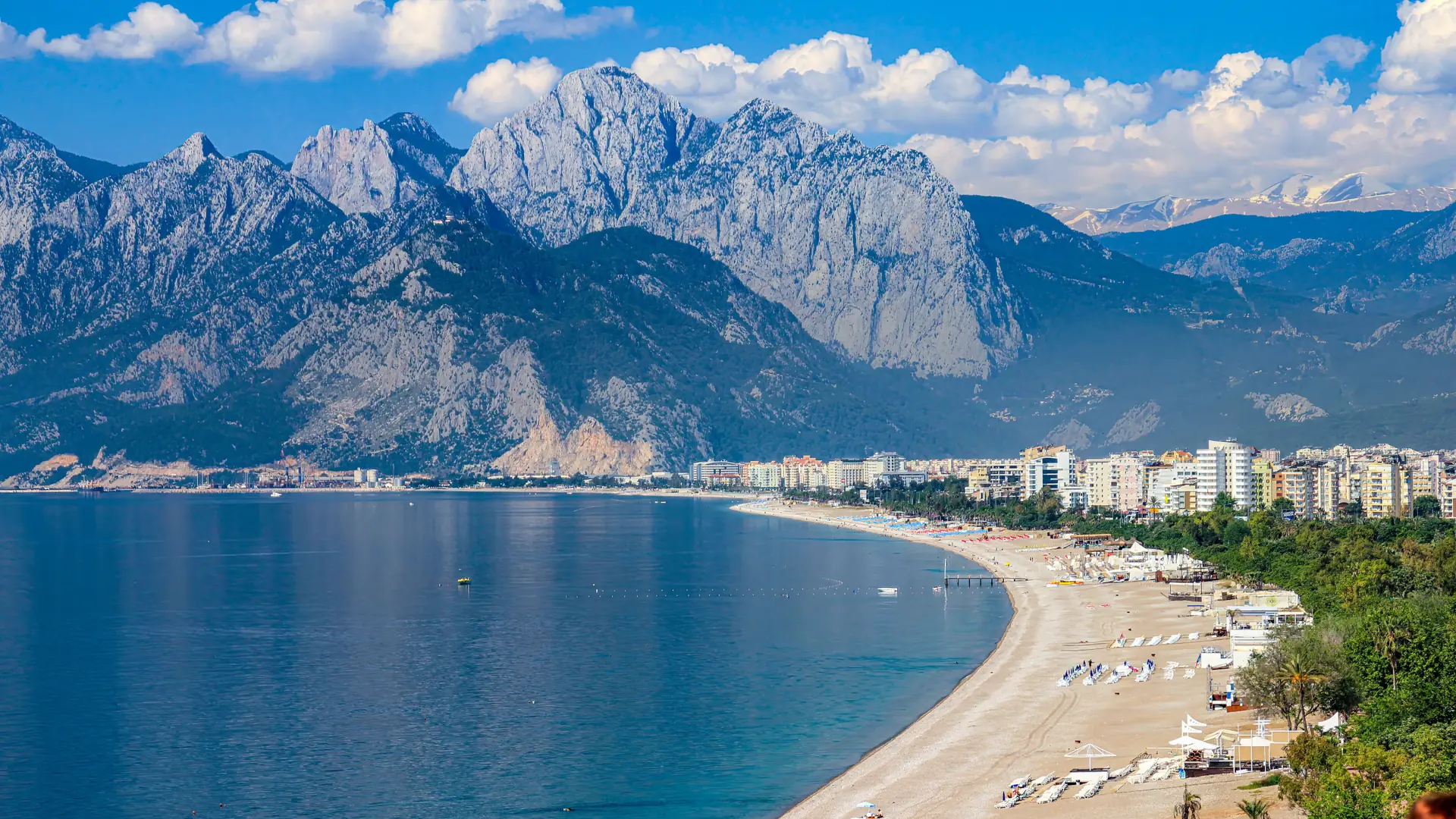 Konyaaltı’s curving pebble beach and Antalya waterfront beneath the Beydağları in sunshine