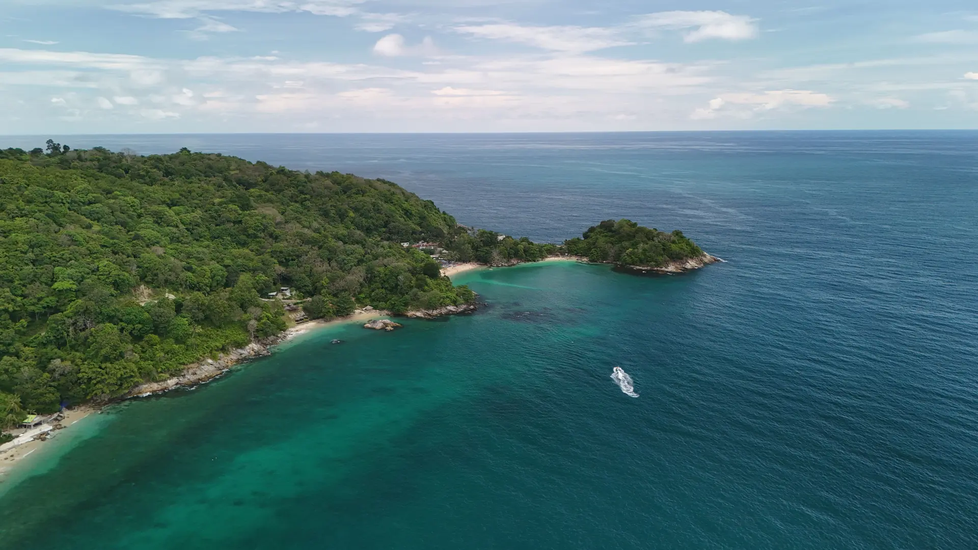 Daylight aerial view of a forested headland and turquoise coves on wider Phuket, rather than Kata