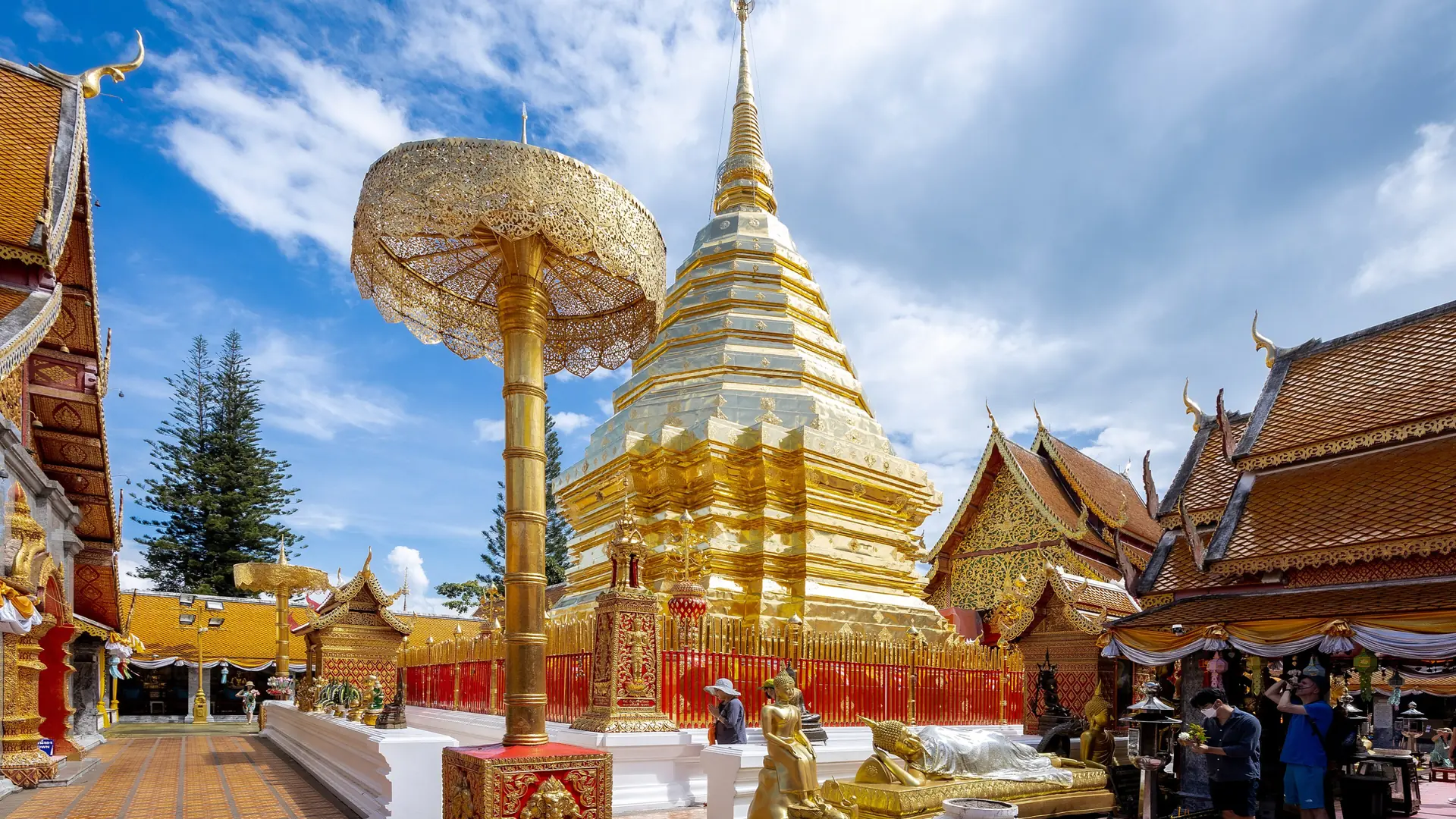 Golden chedi and ceremonial umbrella in the sunlit courtyard of Wat Phra That Doi Suthep